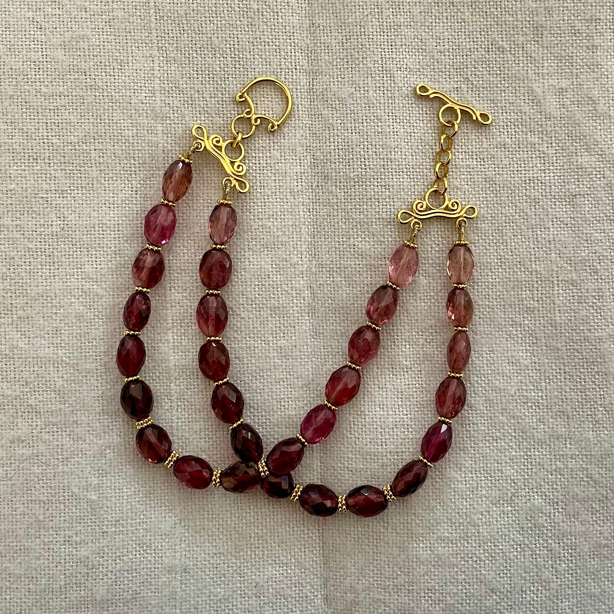 Thirty 7 x 9 mm faceted pink tourmaline beads strung in 2 strands are separated by 18K double granulated spacer beads and finished with a handmade 18K toggle clasp in this beautiful design.  7 inches total length fits most medium to larger wrists. 