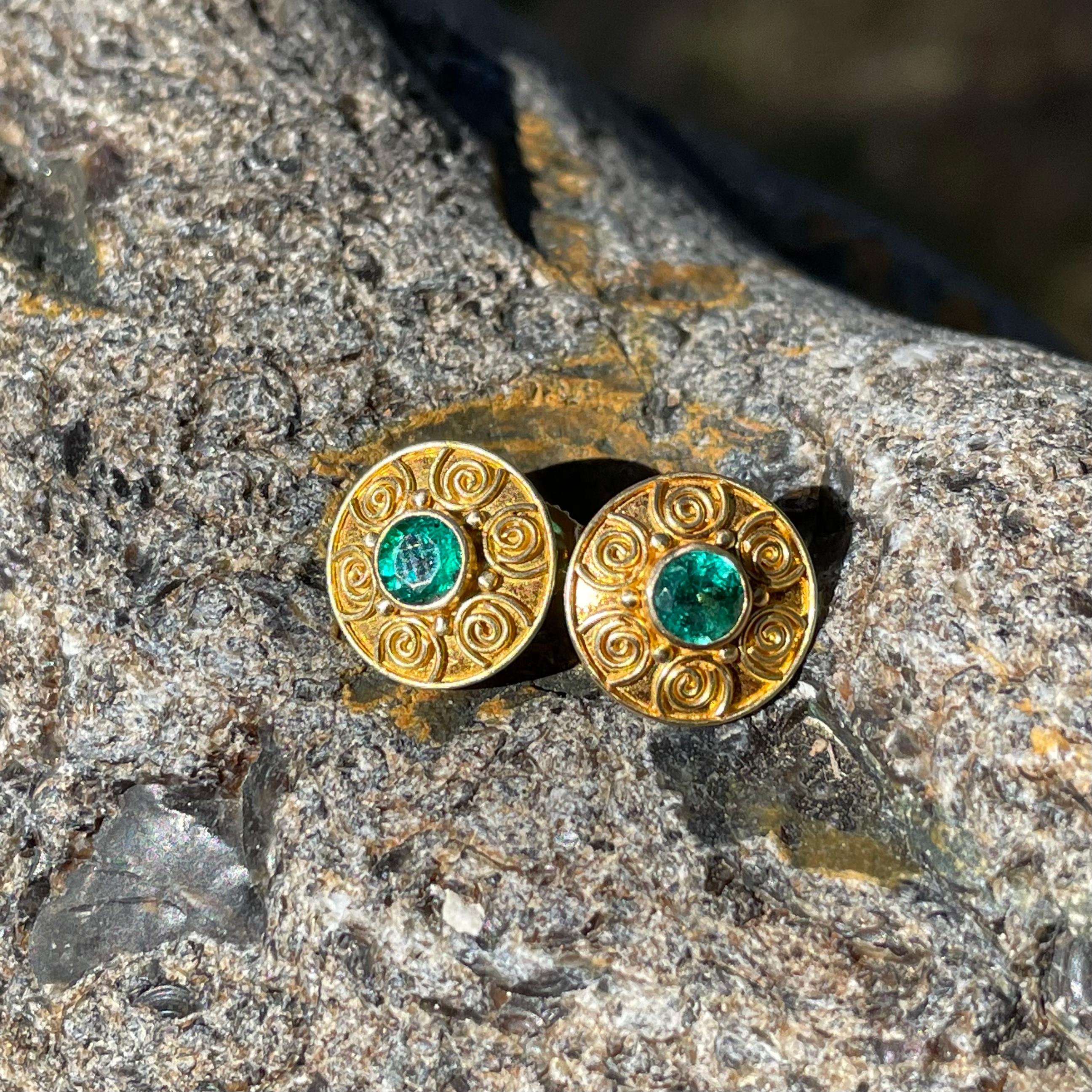 Two brilliant 4mm round faceted emeralds are surrounded by multiple hand applied spirals in this ancient-inspired handmade design. Overall diameter is 11mm.  A nice matte-finish completes these beauties.