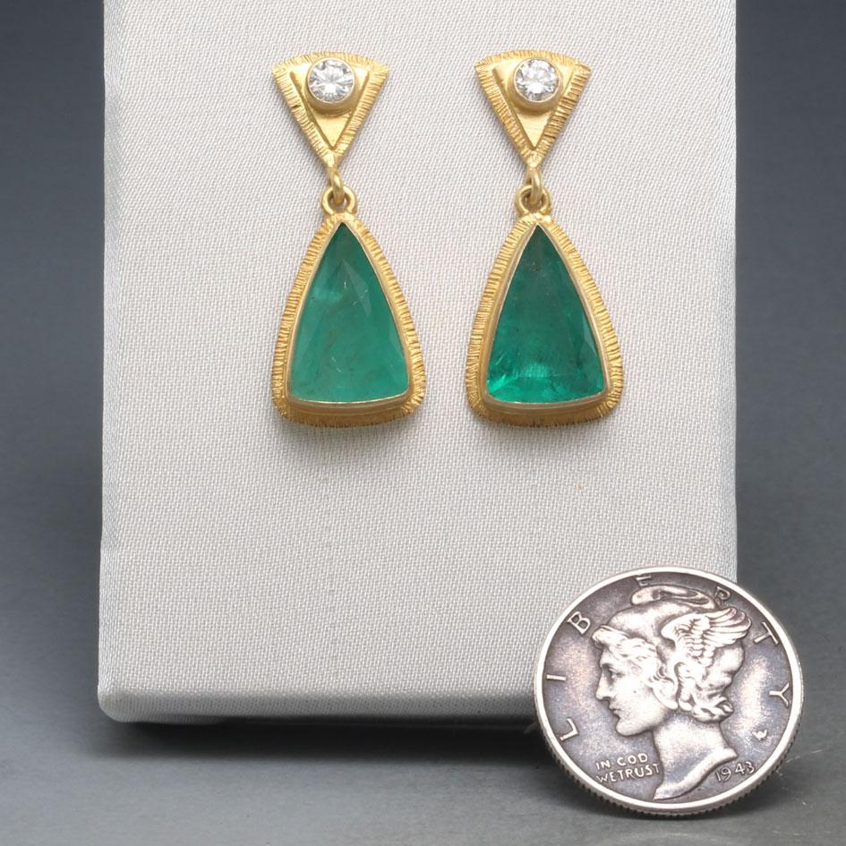 Two crystalline 8 x 12 mm triangular faceted emeralds from the Itabira mines in Minas Gerais, Brazil, are set in handmade 18K 