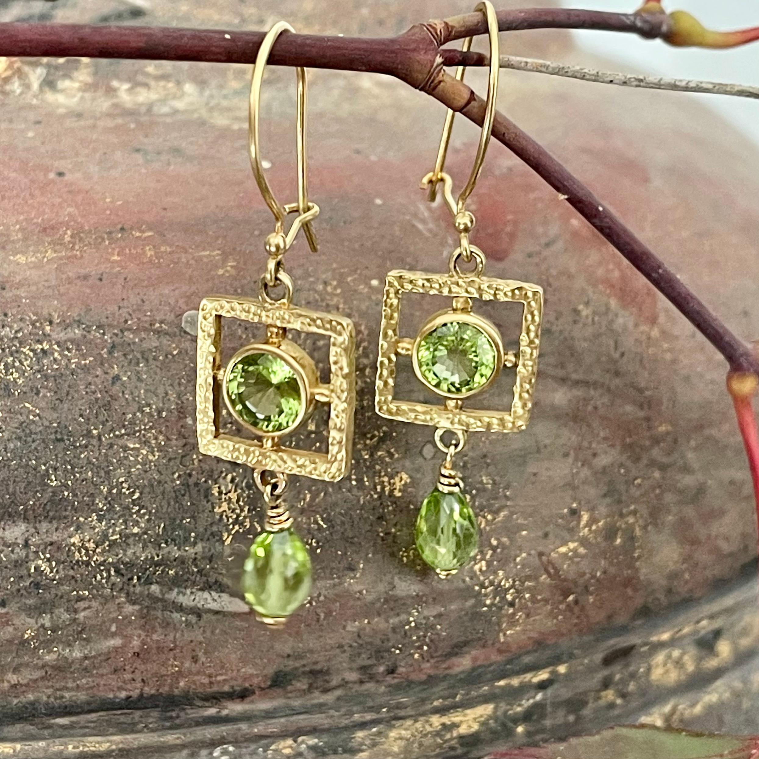 Two 6 mm round faceted peridots are centered within textured and hammered gold squares beneath safety clasp wires.  6 x 8 faceted peridot beads dangle below.  A whimsical juxtaposition of circles squares and ovals.  Sweet.