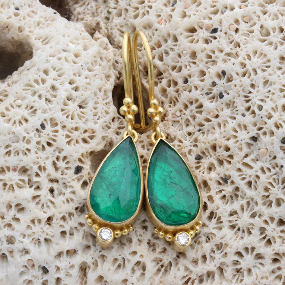 Deux brillantes émeraudes zambiennes en forme de poire de 8 x 14 mm sont serties dans des chatons en or 18 carats au fini mat et ornées de diamants VS1 de 1,9 mm entourés de granulation 