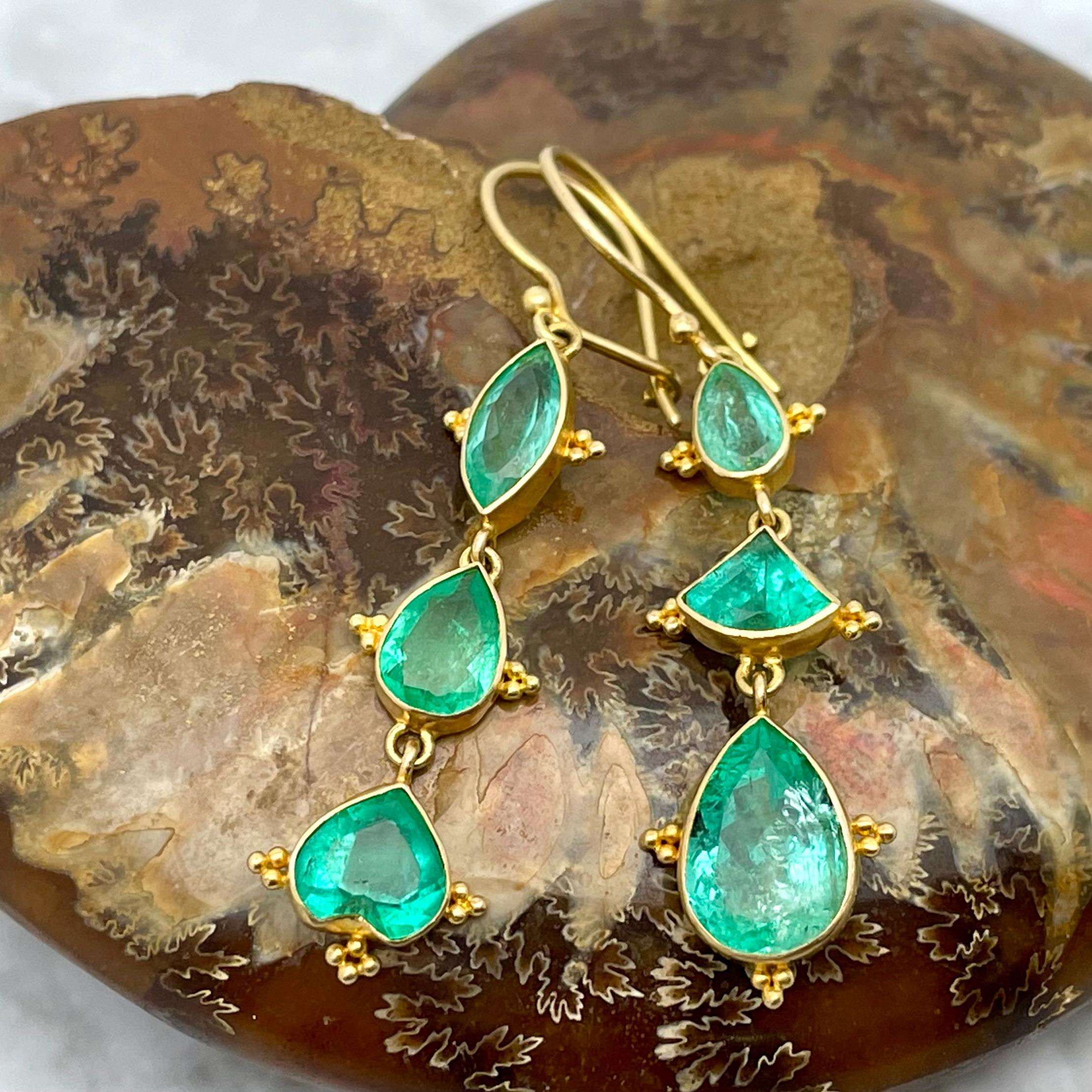 Sei smeraldi colombiani sfaccettati di colore verde chiaro trasparente di forma unica, con dimensioni comprese tra 5 x 7 mm e 8 x 11 mm, sono stati combinati per creare questi orecchini unici nel loro genere.  Piccoli accenti di granulazione 