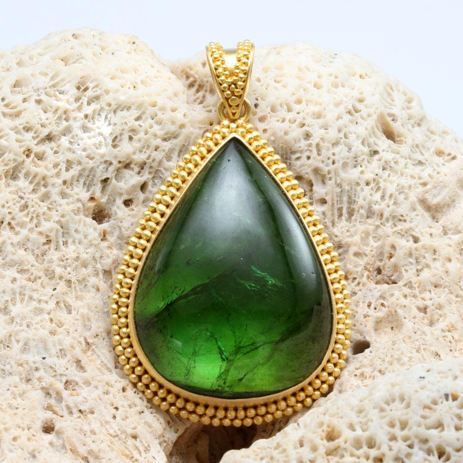 A beautiful large 25 x 33 mm pear shaped Brazilian green tourmaline cabochon rests in a beautiful double row handmade granulated 18K gold setting with complementary bail above.  Unlike, most large green tourmaline cabochons, this incredible stone