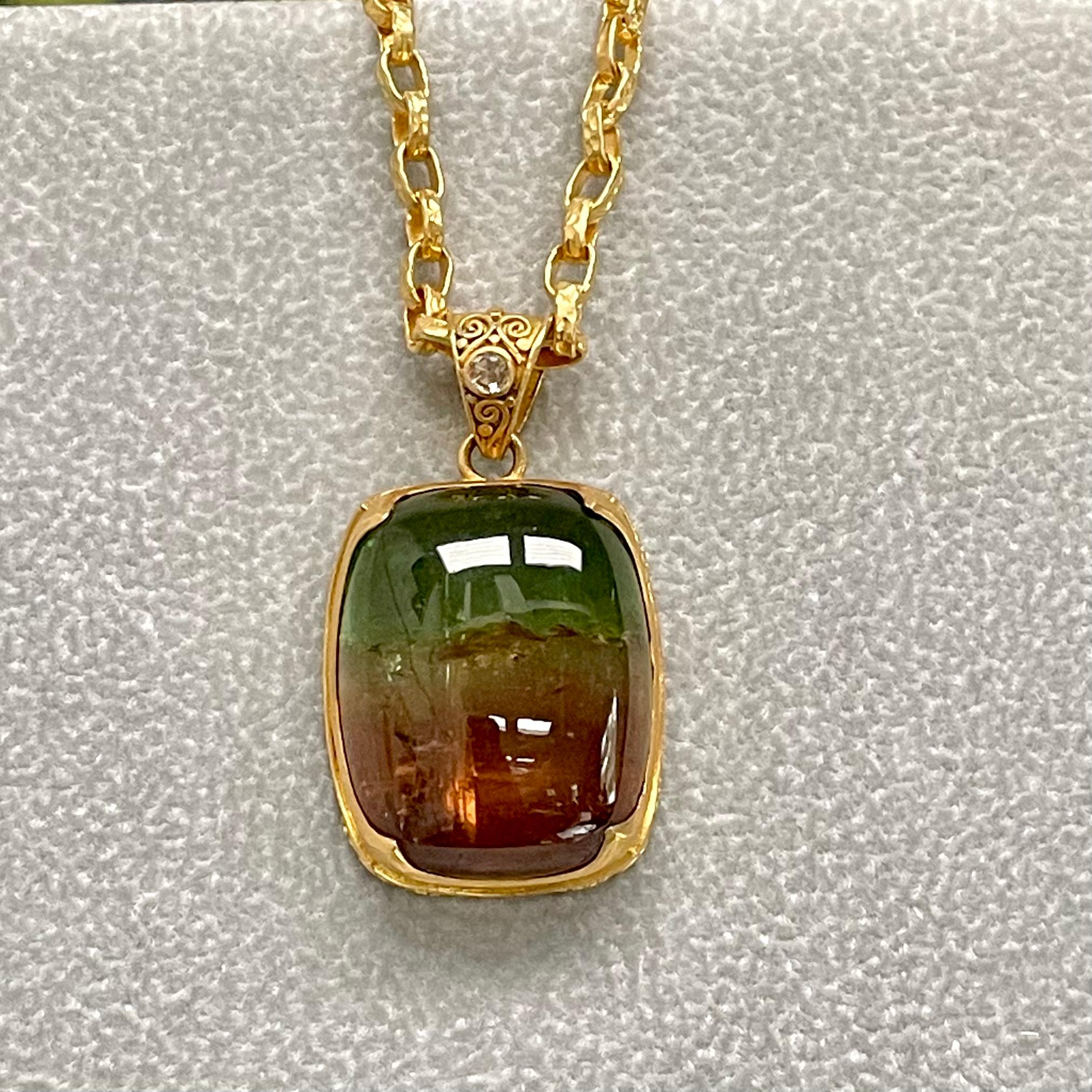 Un cabochon rectangulaire arrondi et joliment gradué de 25 x 30 mm de tourmaline pastèque brésilienne présente une gamme de couleurs entre les verts et les rouges. Elle est sertie dans une monture en or 22 carats 