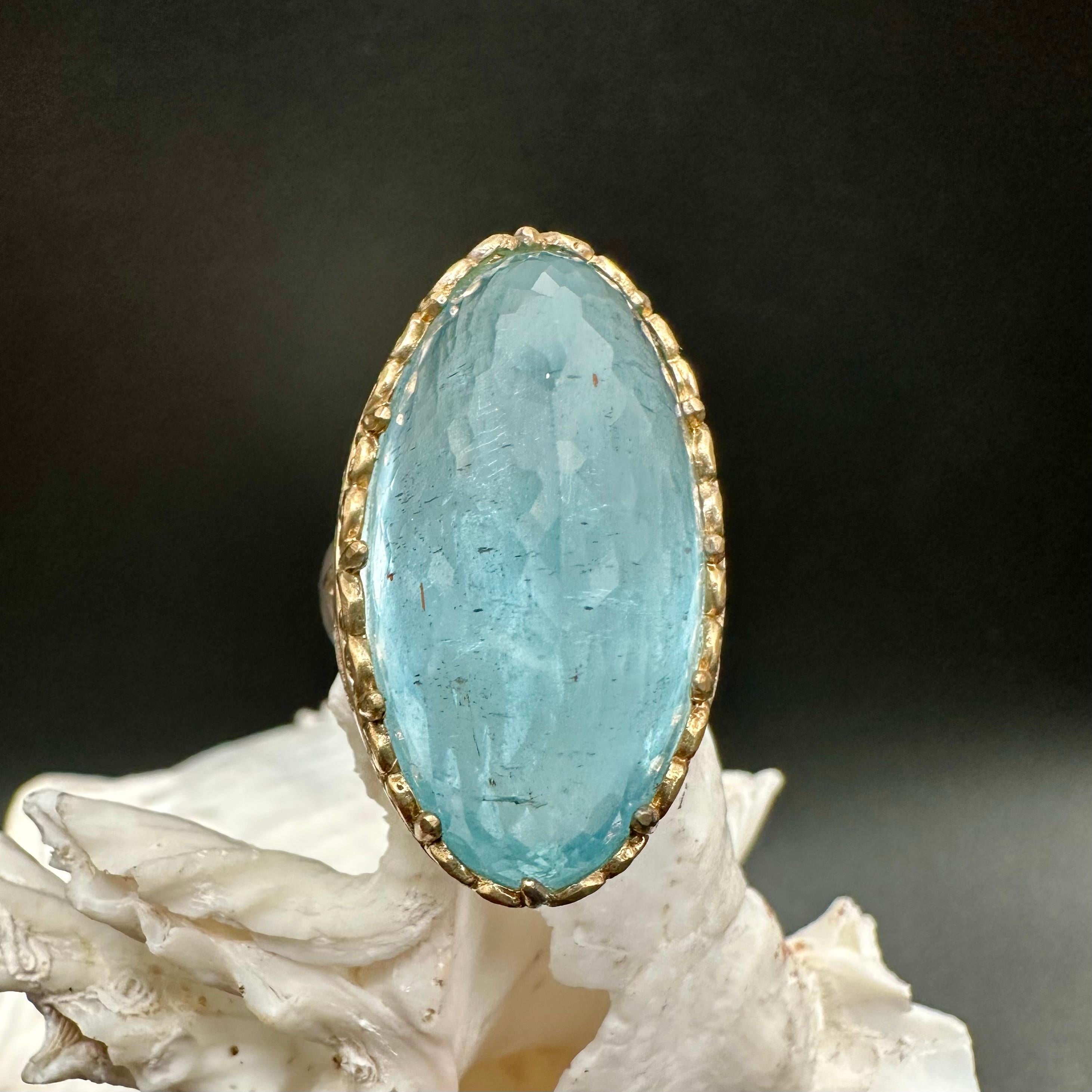 Lasst uns ein Zeichen setzen!  Dieser massive 17 x 33 mm große Aquamarin im Rosenschliff mit Facettenschliff wird an Ihrer Hand mit Sicherheit der Mittelpunkt der Aufmerksamkeit sein.  Der hohe gewölbte Stein ist in einer mit Wachs geschnitzten 18K