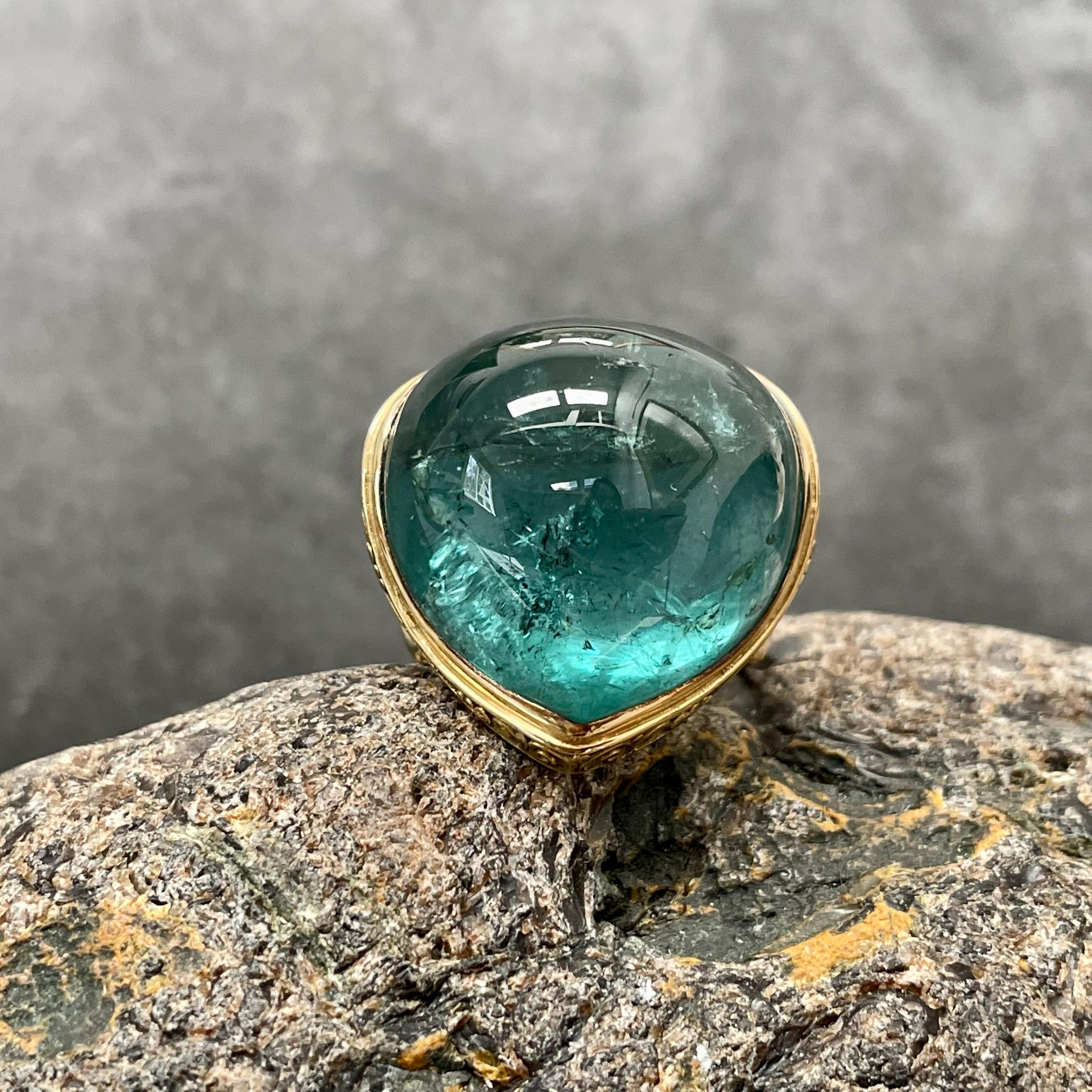 A fabulous 18 x 25 mm pear shaped cabochon Brazilian indicolite tourmaline is set within a one of kind Steven Battelle design.  Indicolite blue tourmaline is the rarest and most sought after color of tourmaline. The shank is a spiraled carved and
