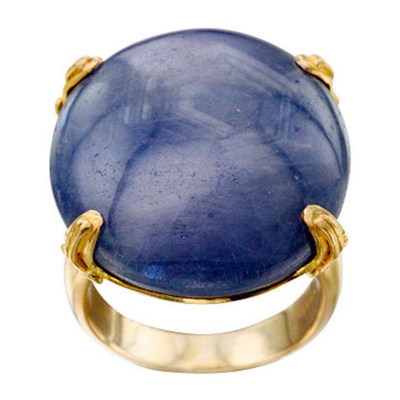 Ein großer, 22 x 28 mm großer, ovaler blauer Cabochon-Saphir, der ein interessantes sechseckiges Muster aufweist, das die kristalline Gitterstruktur des Saphir-Edelsteins demonstriert, bildet das magische Herzstück dieses Rings aus 18 Karat Gold.