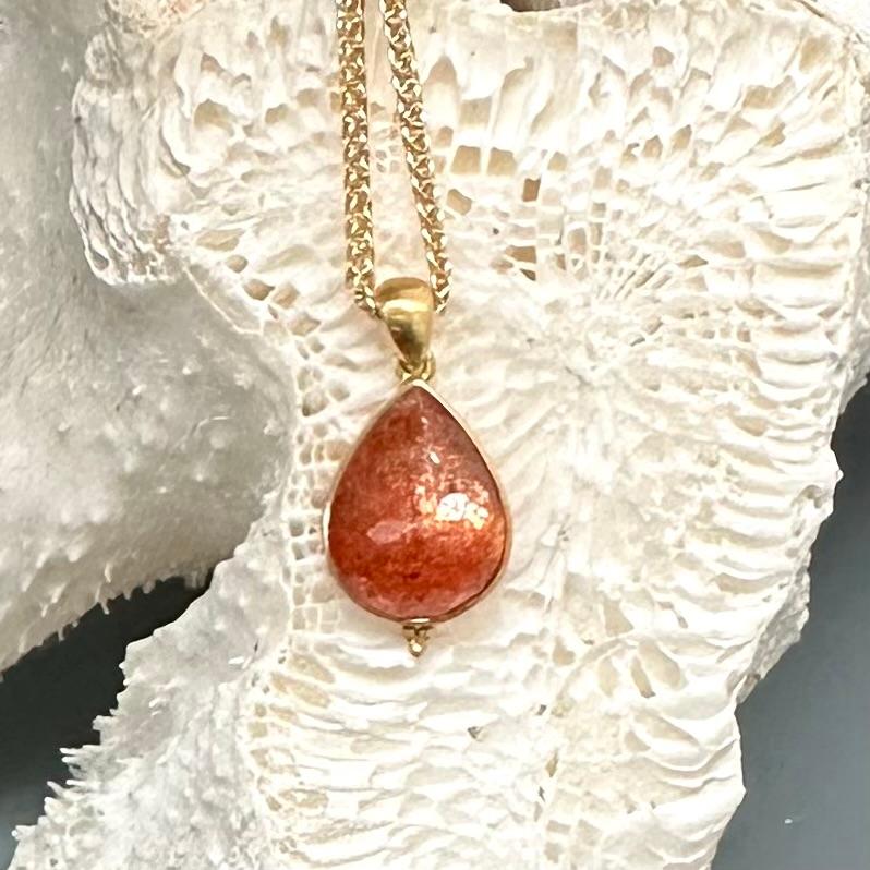 An 11 x 15 mm pear shaped faceted sunstone from the Tamil Nadu region of India  shows a distinct and lively glitter called 