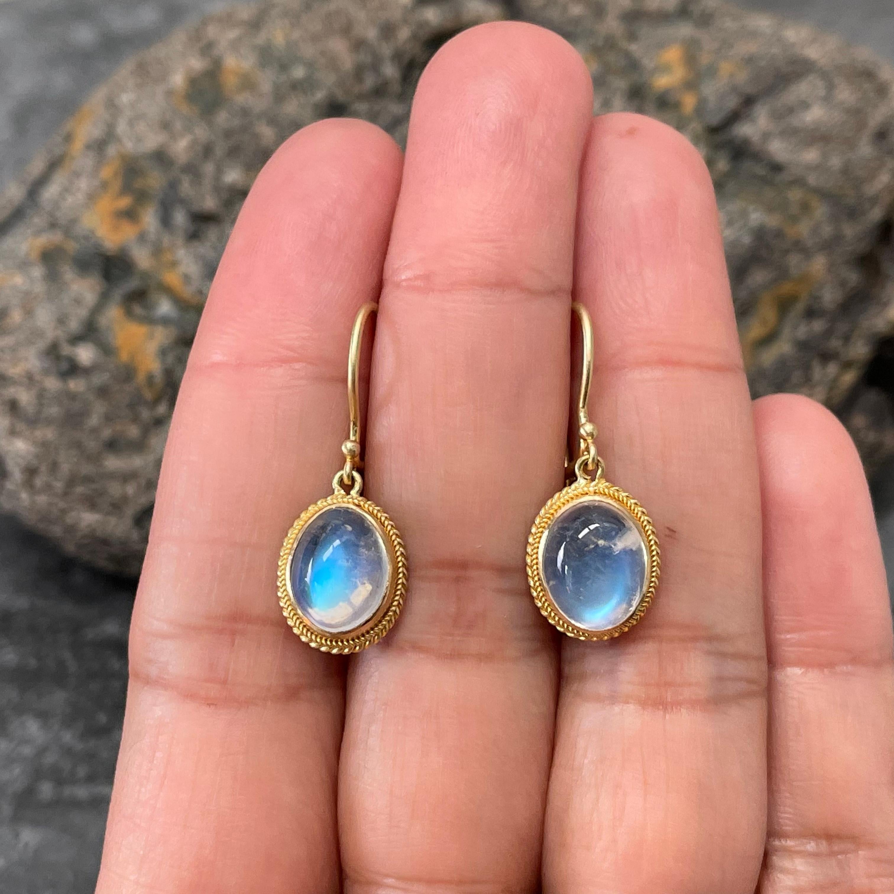 Two glowing blue 8 x 10 mm oval rainbow moonstone cabochons are held in double twist wire handmade bezels in this simple yet classic design. Safety clasp wires. These stones are clean and lively.  Nice !