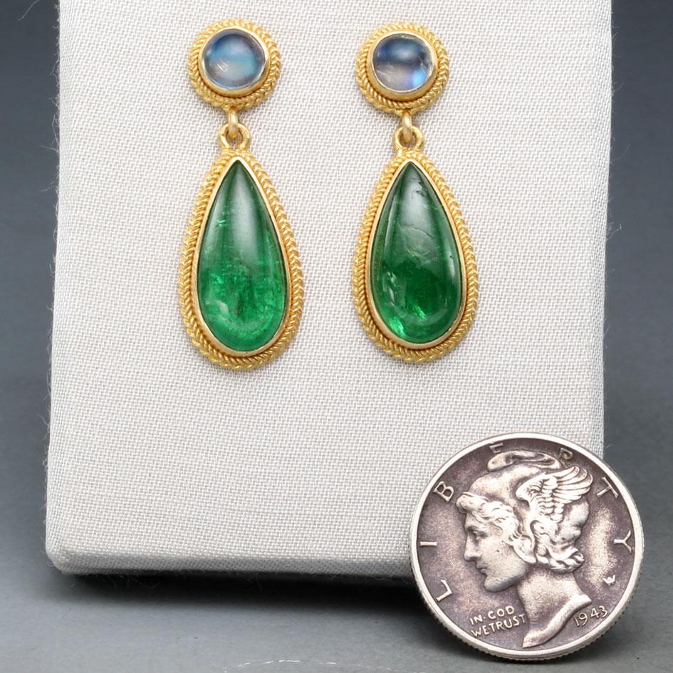 Two vivid bright green 7 x 14 mm pear shaped tsavorite cabochons glow below 5mm magical blue sheen rainbow moonstone cabochons, all wrapped in rich handmade large/small 18K gold twist wire decorated bezels in this opulent and eye-catching post