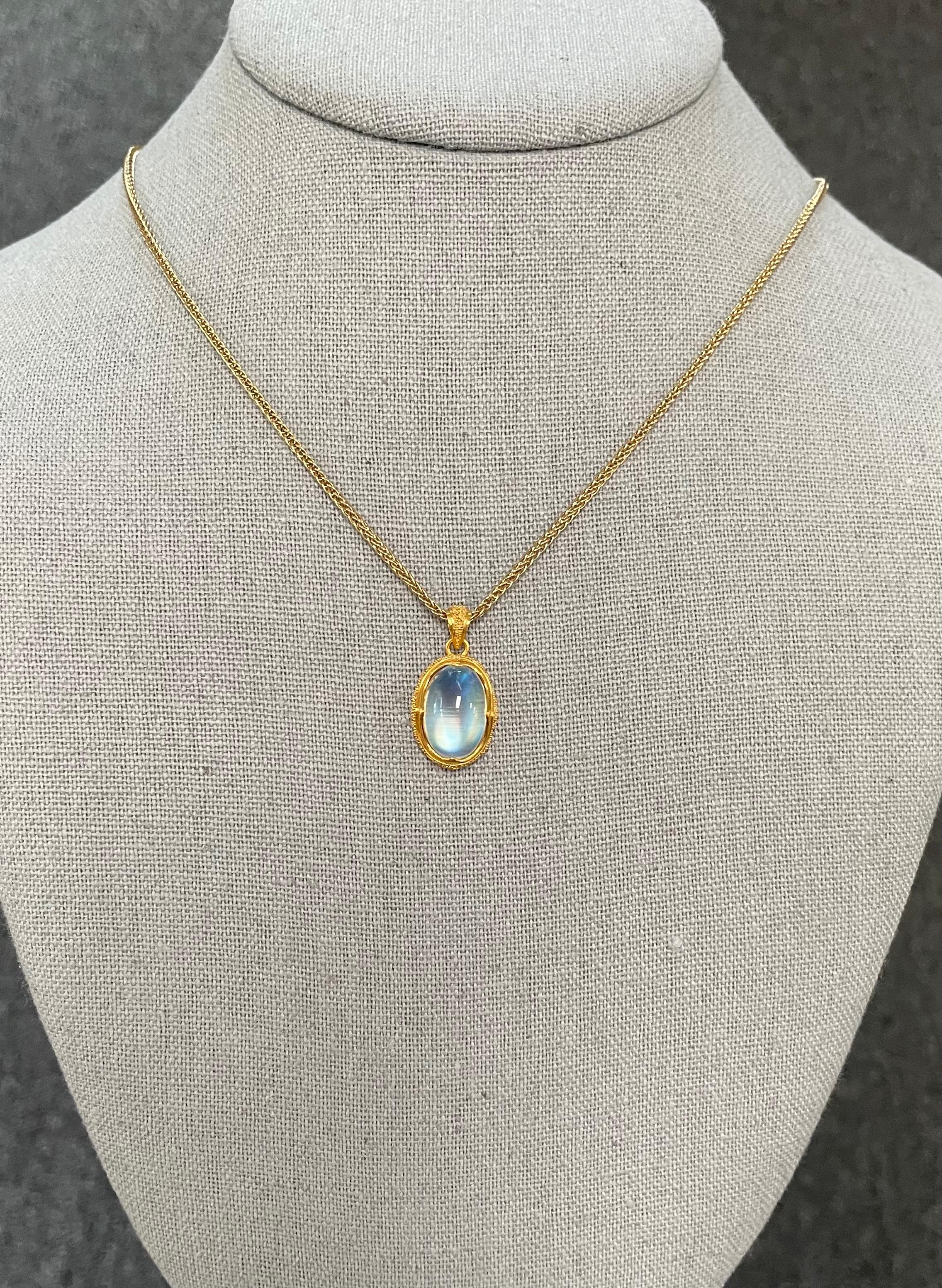 Une pierre de lune arc-en-ciel ovale et scintillante de 10 x 15 mm est maintenue dans une monture granulée à la main, d'inspiration ancienne, 