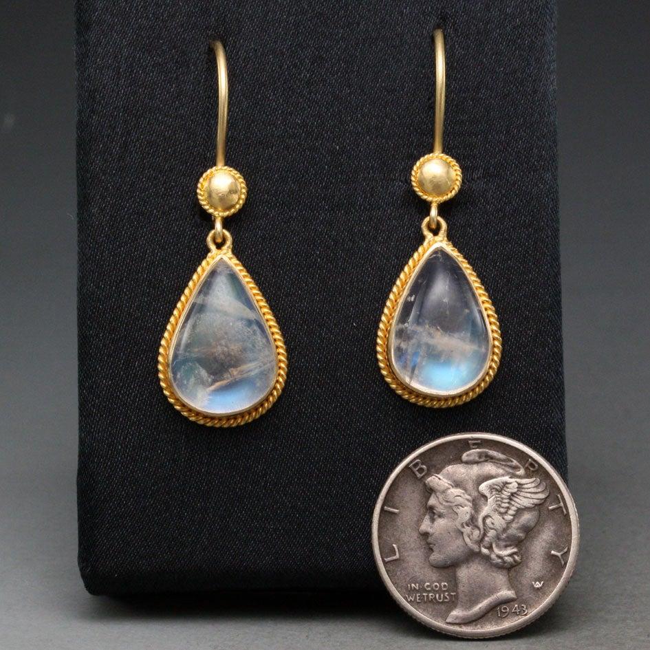 A pair of shimmering 9 x 13 mm pear shaped Rainbow Moonstones are surrounded by delicate twist wire accents in this Steven Battelle designed creation.  Safety clasp wires protect. Magical!
