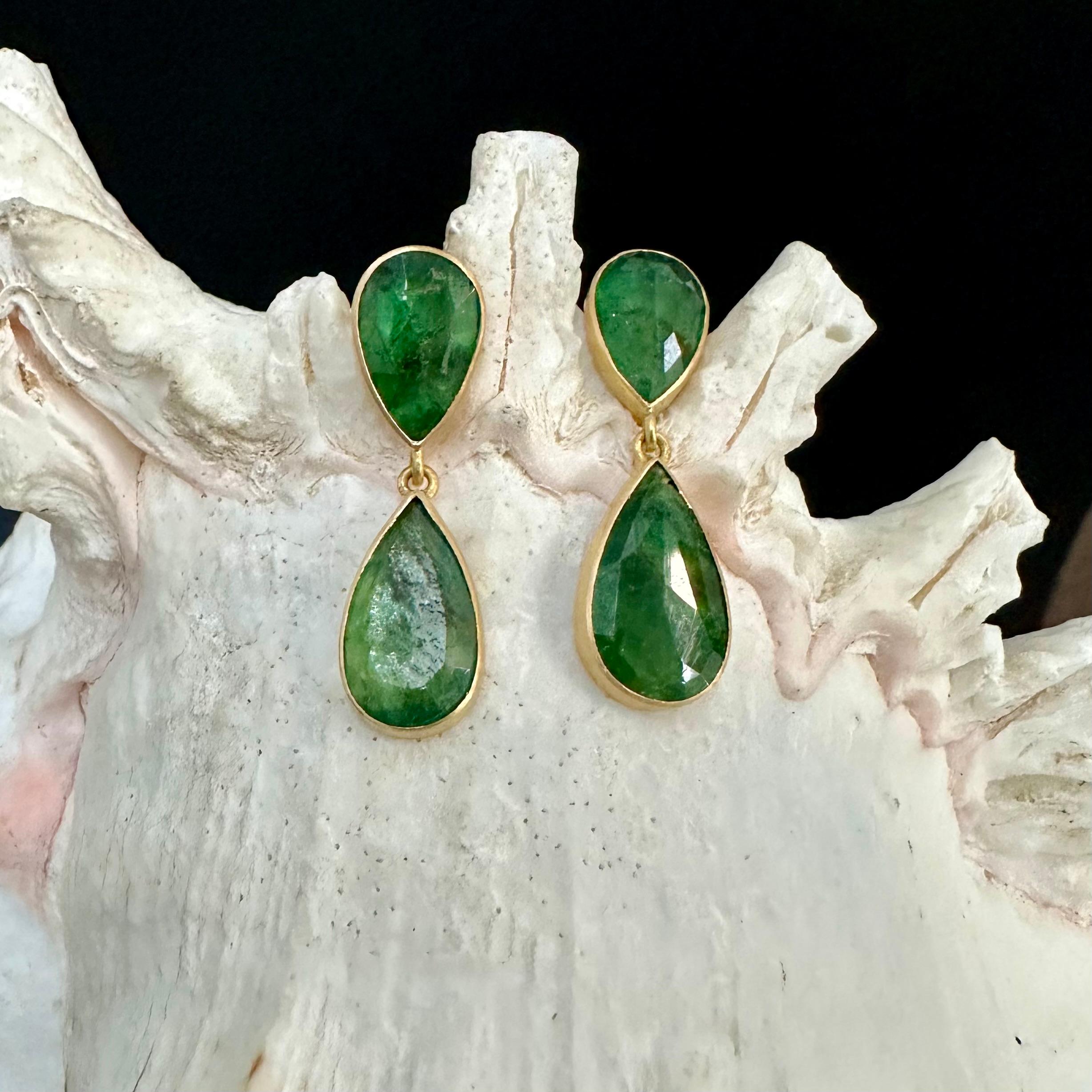 Ultimately simple large faceted pear shaped emeralds of 8 x 12 mm and 9 x 15 mm are arranged in classic geometric opposition in these impressive earrings set in matte-finish 18K gold.  Comfortable silicone ear nuts complete.  No need for extra