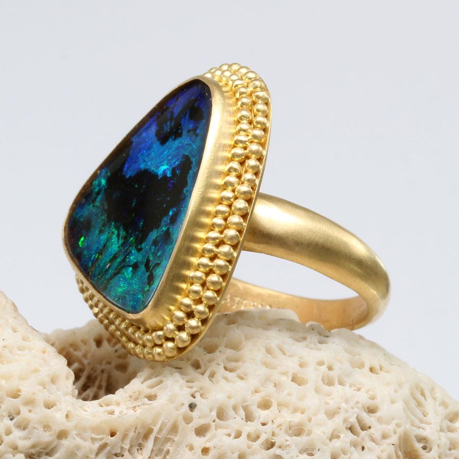 Ein wunderschöner, elektrisch blauer und gr�üner, ca. 15 x 17 mm großer, dreieckiger australischer Boulder-Opal aus den Quilpie-Opalfeldern in Queensland ist von 2 Reihen gestapelter Granulation umgeben, um den Stein in diesem handgefertigten Steven