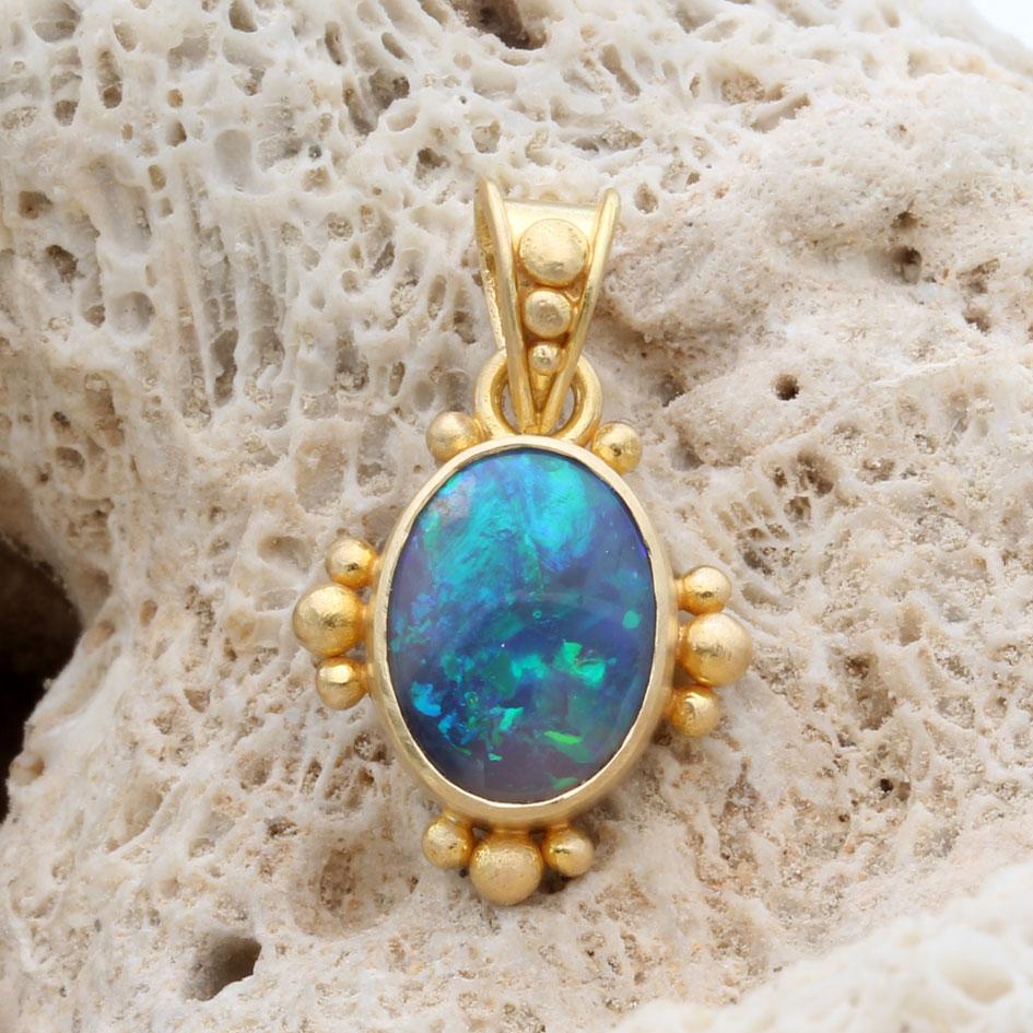 Un bellissimo opale nero australiano verde e blu lampeggiante di 7 x 10 mm, proveniente dai giacimenti di opale di Coober Pedy, nell'Australia Meridionale, è incastonato in un castone in oro 18 carati lavorato artigianalmente con granulazioni