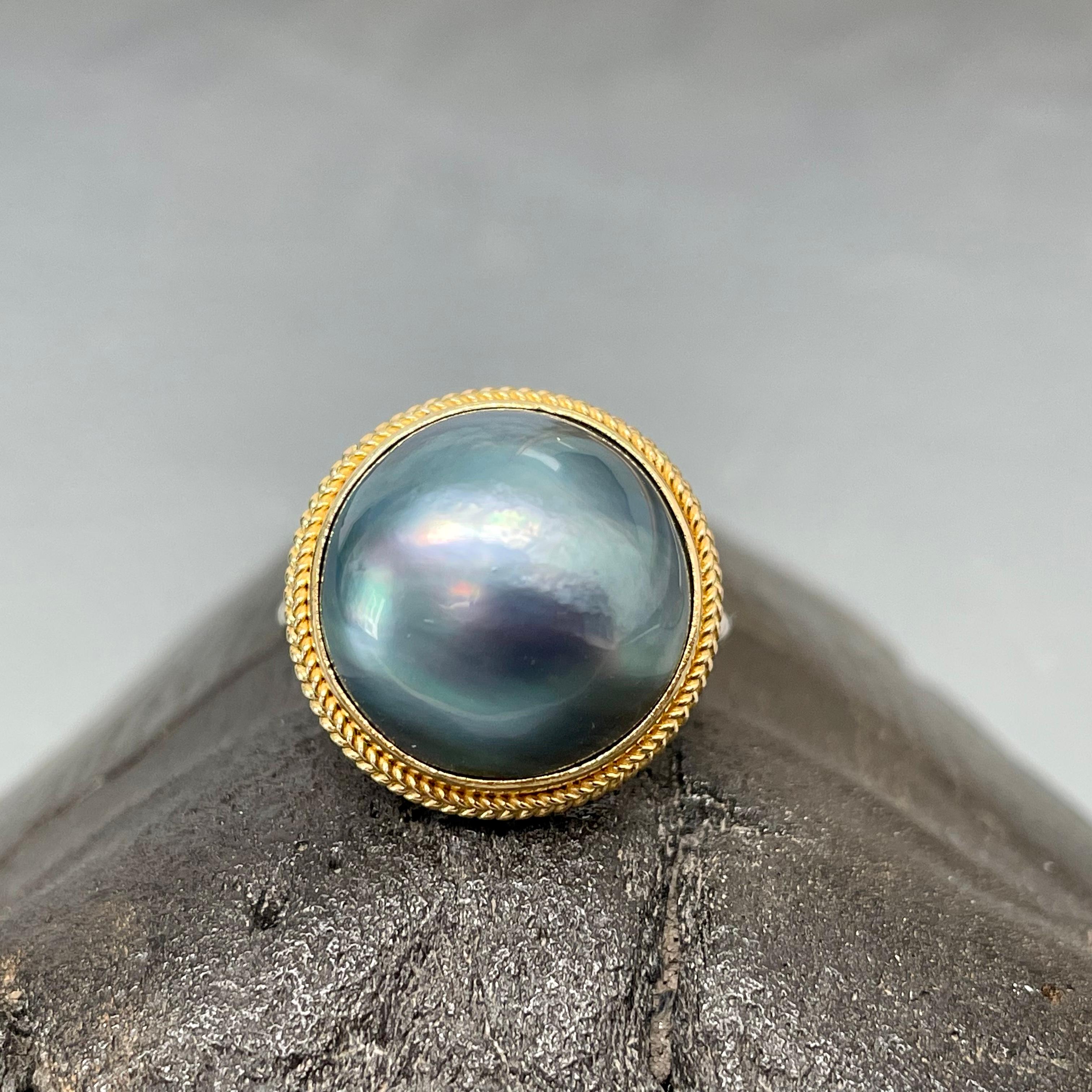 A lustrous black fresh water ??? 10mm Mabe pearl is set in classic large/small twist wire 18K gold bezel with a handmade sterling twisted wire shank .  An expensive look from above, as the sterling shank is not really seen.  Beautiful contrast