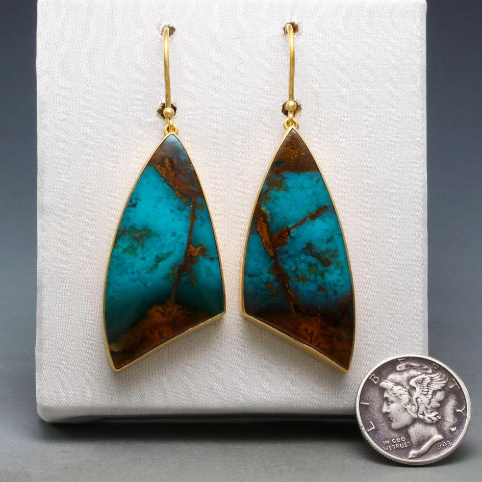 Two variegated 17 x 37 mm curved trillium shaped cabochons of Javanese Blue Opalized Petrified Wood are set in simple brushed 18K bezels suspended below safety-clasp 18K ear wires.  This is a relatively new stone in the market that comes from 20