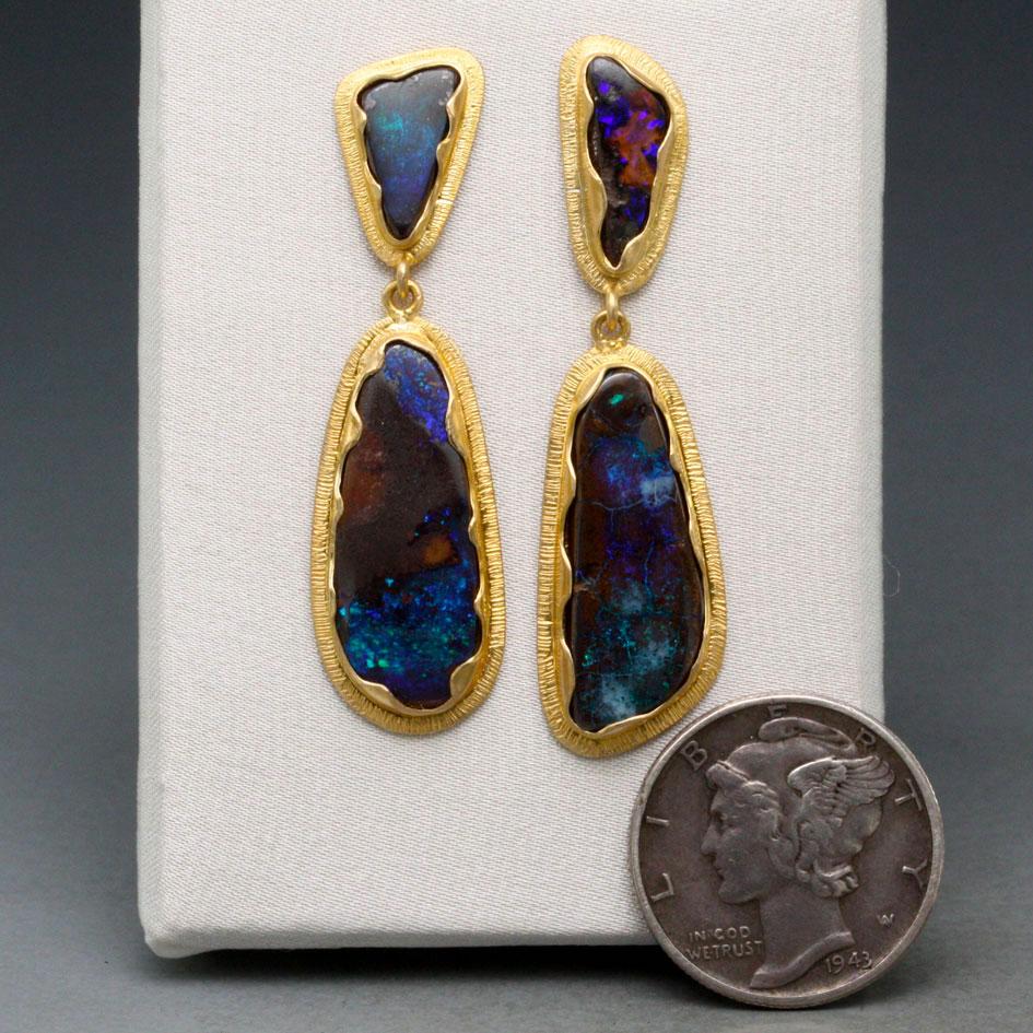 Beautiful irregular Queensland Australian Boulder Opals with flashing blues are set in handmade wavy and textured 18K bezels really draw the eyes. Almost 10 carats total. 
Wight 5.78 gram
Length 40mm
Width 10mm
Stones size 5x9mm x, 8x20mm x

