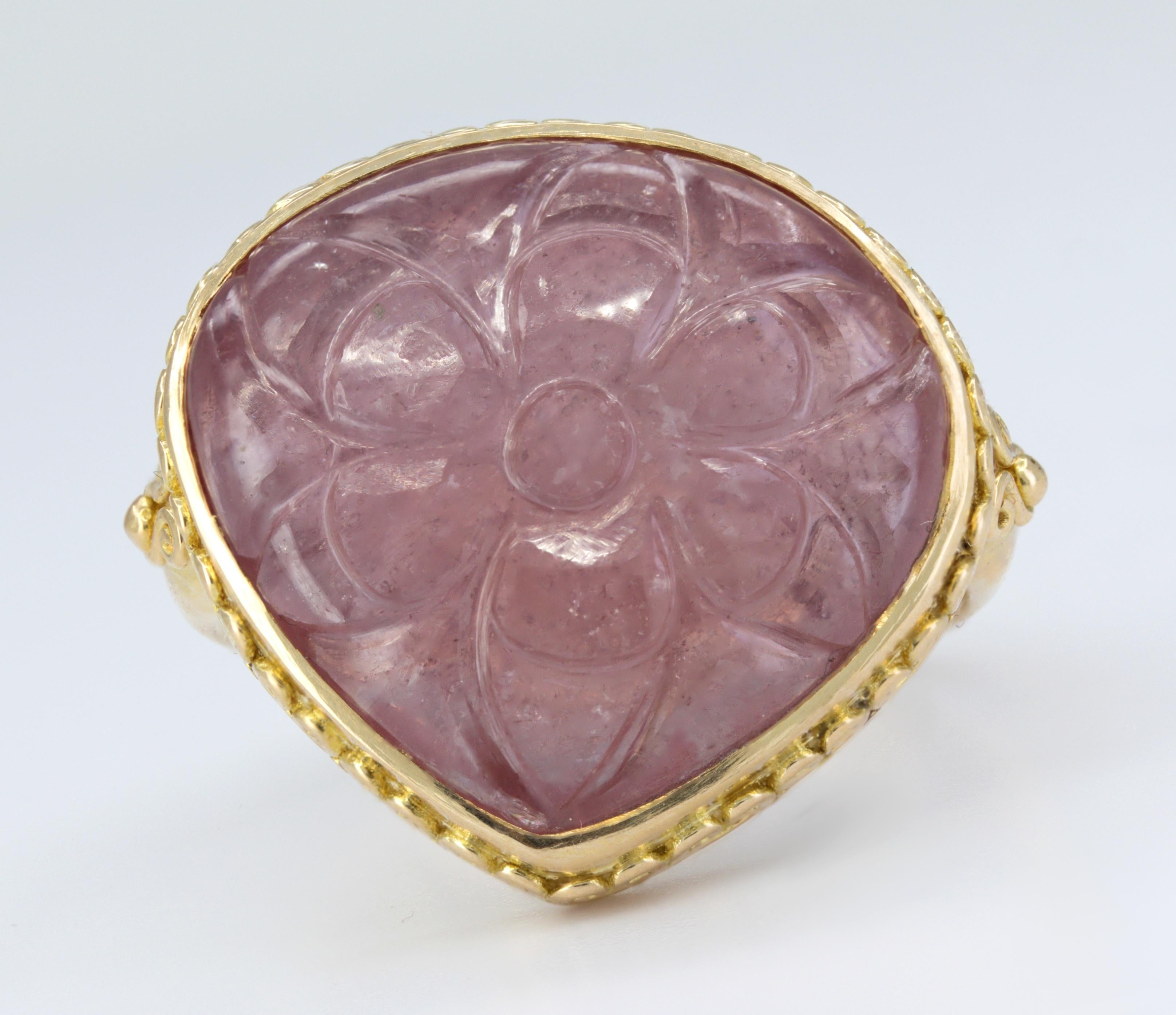 Featuring (1) carved pear-shaped ruby flower cabochon, 19.5 X 18.7 X 7.00 mm, bezel set in an 18k yellow gold, 20.5 X 21.3 mm tapering to 3.1 mm, size 5.25 (with inside ball sizer), marked BATTELLE 18K, Gross weight 12.47 grams.