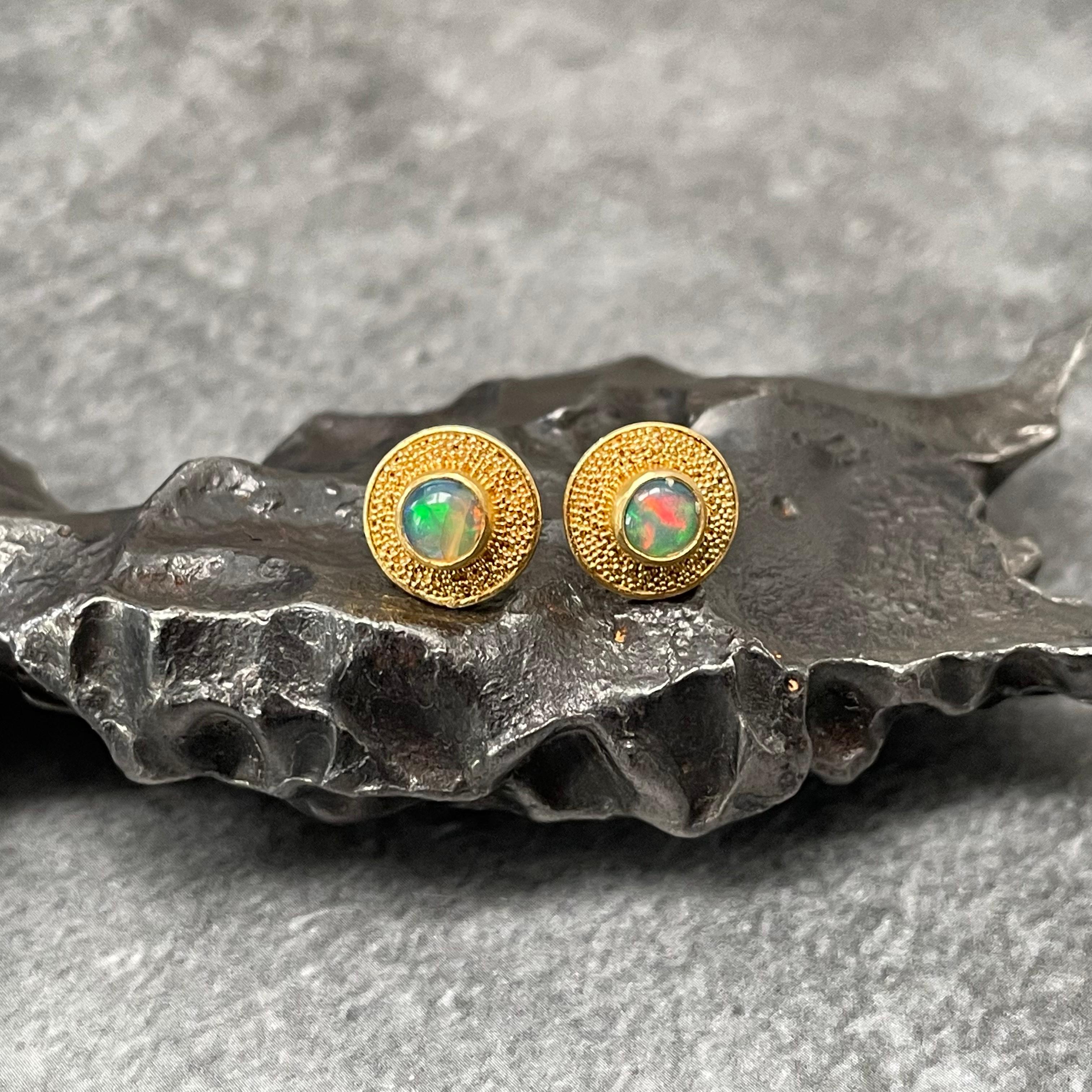 Two lively 4 mm cabochons of flashing green, blue, and red Ethiopian opals are surrounded by fine 