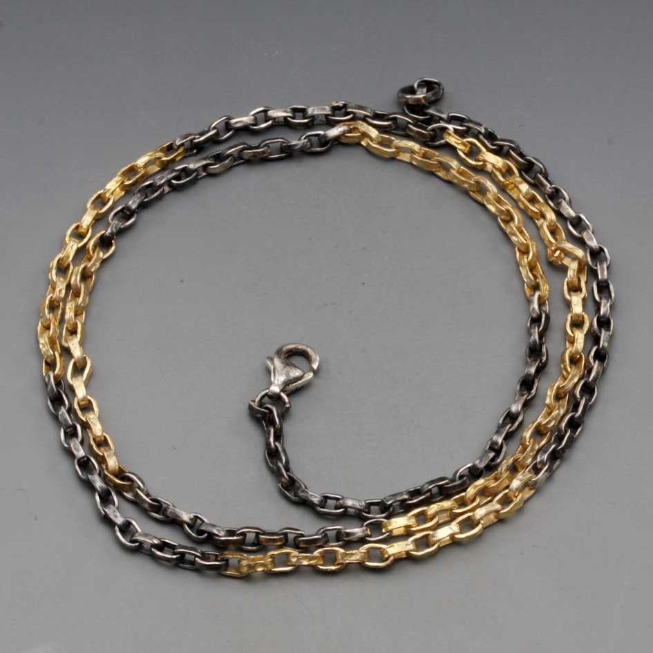 Una catena fatta a mano con maglie organiche martellate che alternano oro giallo 18 carati e argento scuro ossidato è un pezzo bellissimo da solo o da usare con un ciondolo.  Le maglie sono larghe circa 1,1 mm. Ci sono 32 link d'oro nella parte