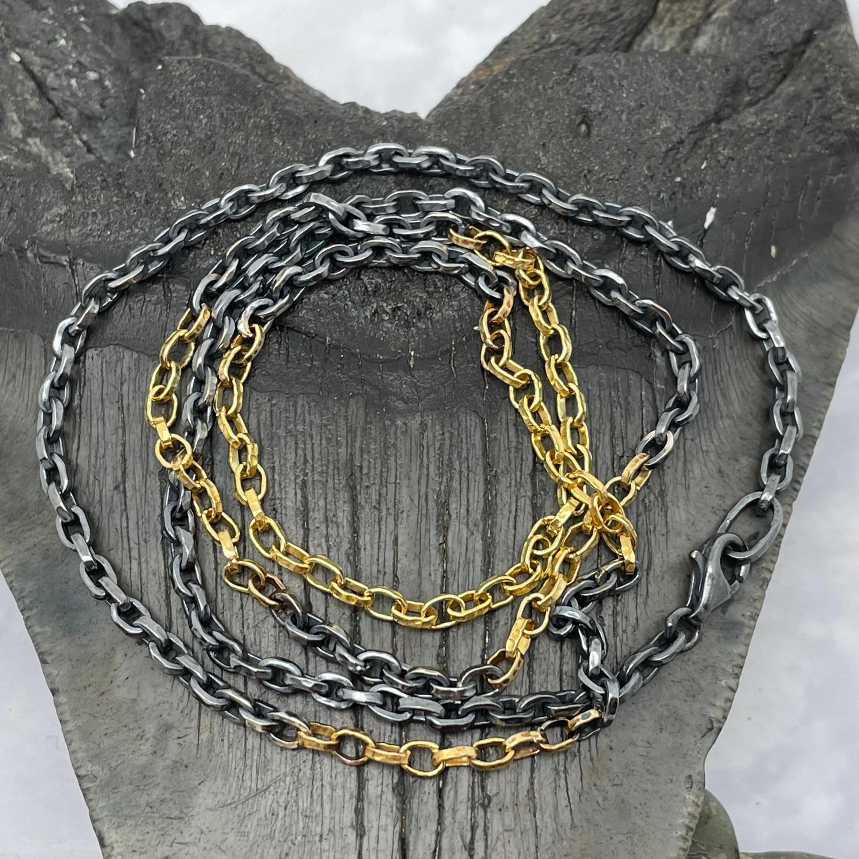 A unique organic design features 32 handmade links of 1.1 mm width 18K gold at bottom, then (after a separator of oxidized silver links between) 12 links, and finally 9 links of gold.  The matte-finish gold with rough oxidized silver provides a rich