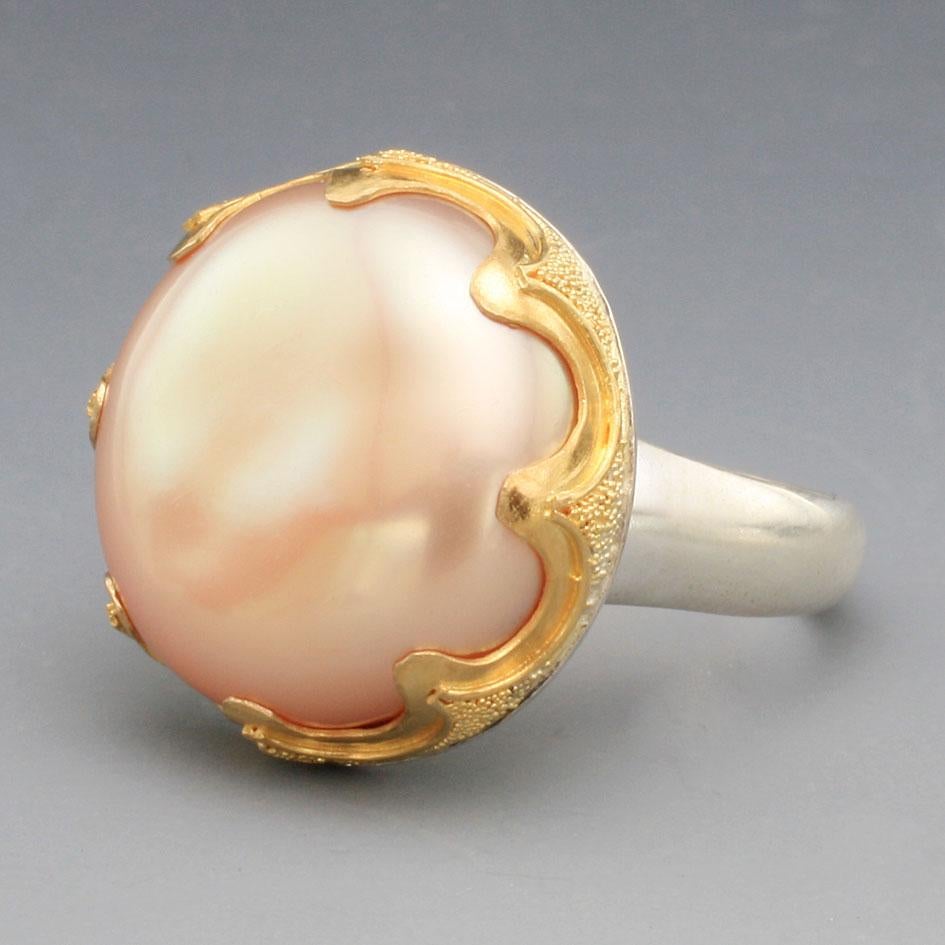 A lustrous 19 mm pink freshwater round button pearl is highlighted in a 22K gold fine 