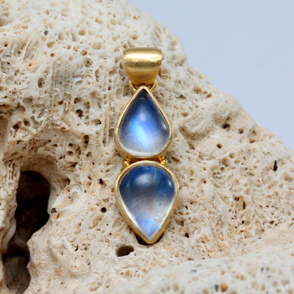 7 x 9 mm and 8 x 10 mm pear cabochons of shimmering rainbow moonstone are held in 18K gold opposition with 2 small 