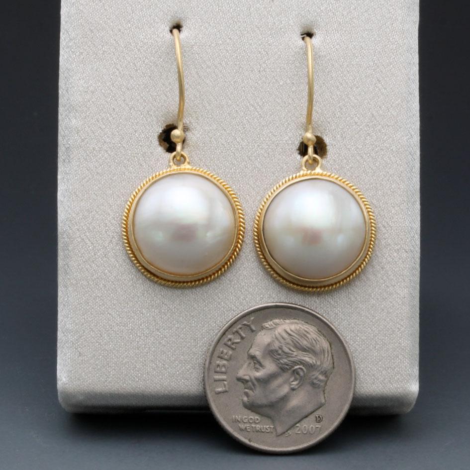 Two lustrous 13 mm white Mabes are held in twist wire accented 18K gold bezels hanging below safety clasp 18K ear wires in this ultimately simple, classic design.  You can't go wrong with pearls!