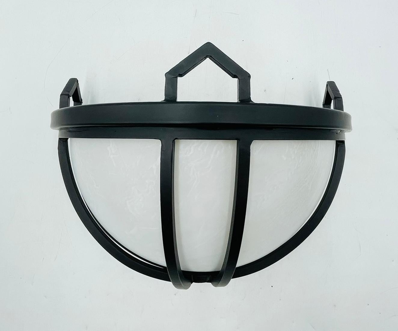 Un'applique di Steven Handelman Studio, modello Parma, realizzata nell'ottobre 2022 a Santa Barbara, California. Questo elegante apparecchio a mezza cupola è caratterizzato da una robusta struttura in ferro battuto rifinita in nero opaco, che