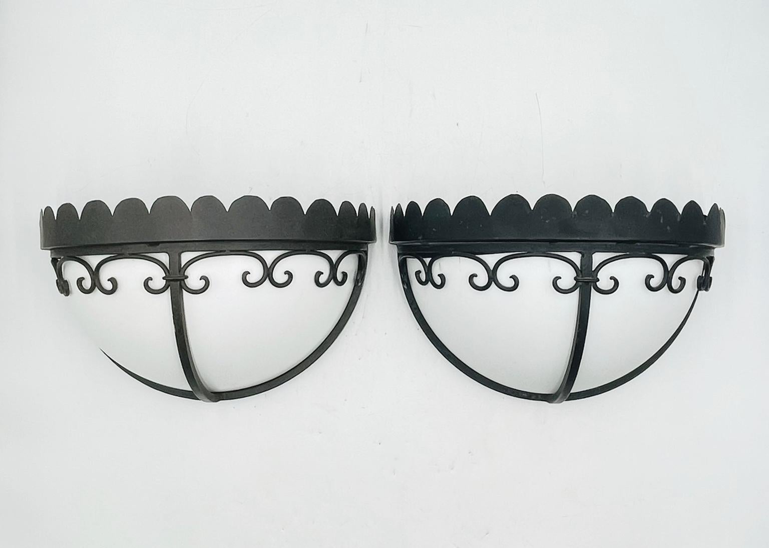 Elegant pair of custom wrought iron wall sconces with white Lucite shades, designed and handcrafted in 2004 by Steven Handelman Studios, Santa Barbara, California. These high-quality sconces feature a half-dome form with decorative scalloped tops