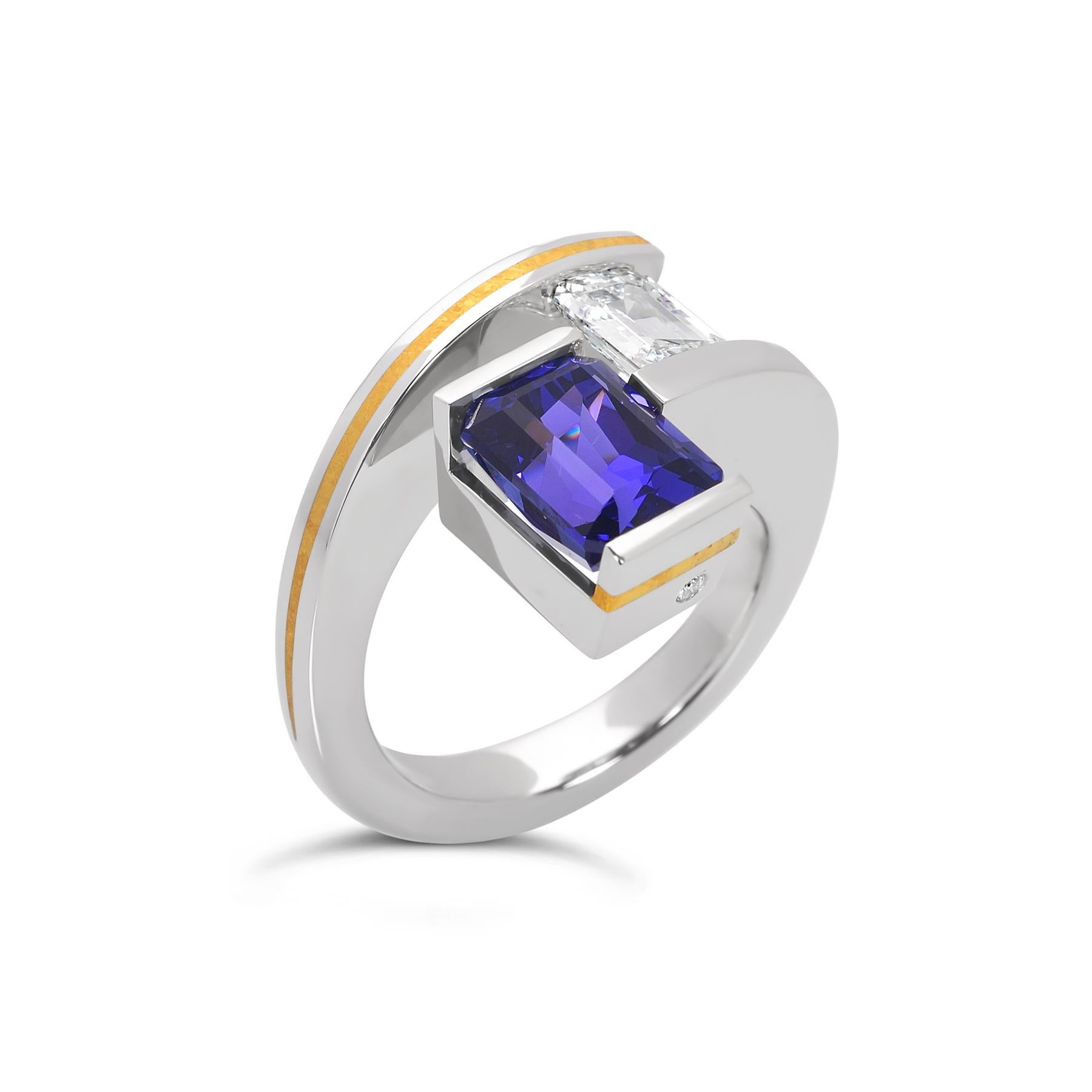 The 2-Stone Helix Ring with tanzanite and diamond is handcrafted in platinum with custom 24k crystalized gold inlay accents. The ring features a 3.61 ct. deep blue-purple tanzanite and a tension-set 0.78 ct. E/VS2 emerald cut diamond (GIA