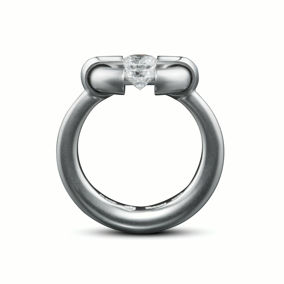 The Steven Kretchmer 2-Stone Jazz ring with 2 Tension-Set diamonds is handcrafted in platinum with a half matte finish. The ring features two round brilliant diamonds, one tension-set 0.33ct. F/Si1 stone on the edge and one 0.50ct. F/Si1 tension-set