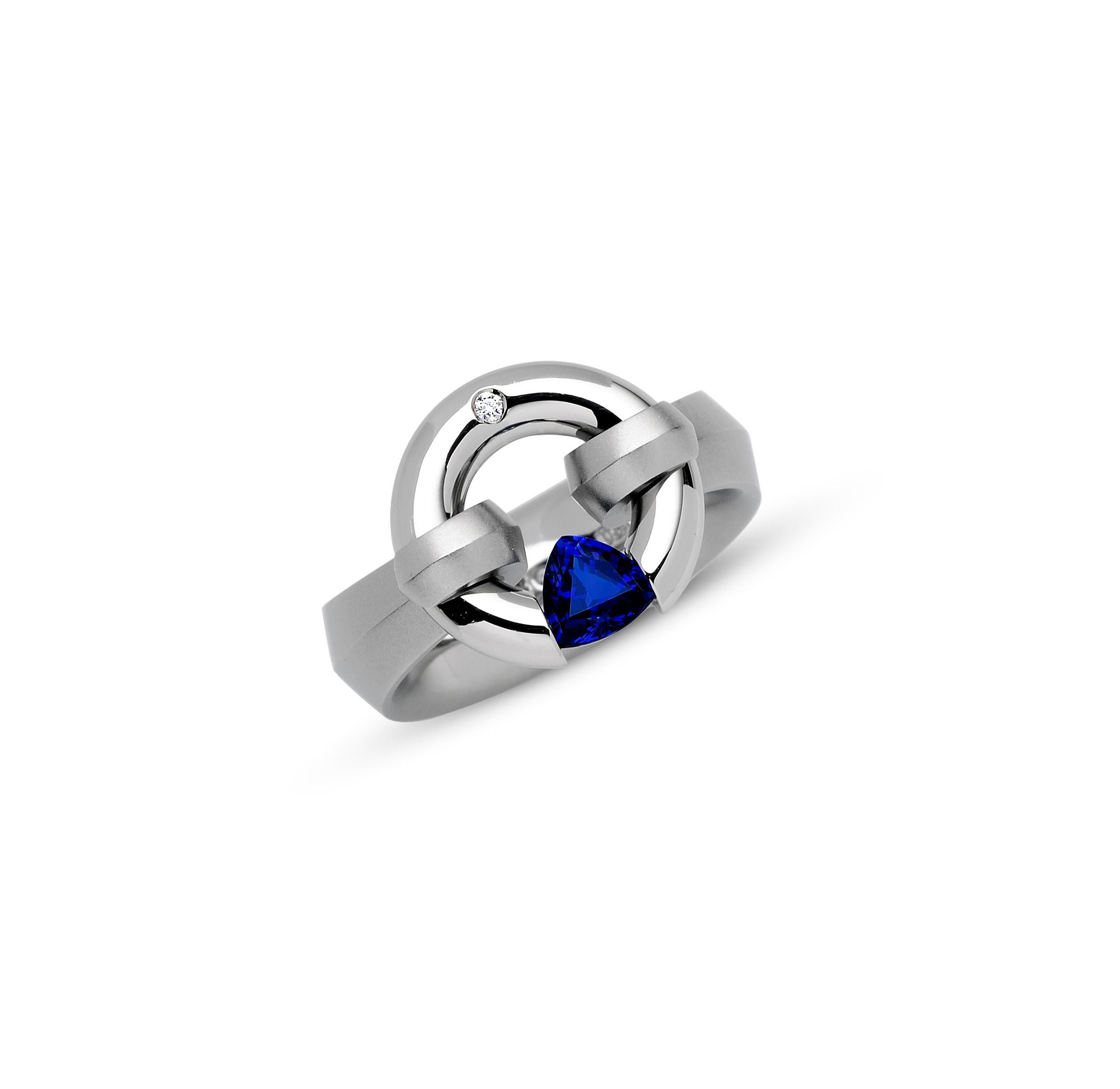The Steven Kretchmer Wide Harp jazz Ring with a tension-set blue sapphire is handcrafted in platinum with a half matte finish. The 0.69 ct. trillion sapphire is a rich, royal blue (5mm). The 