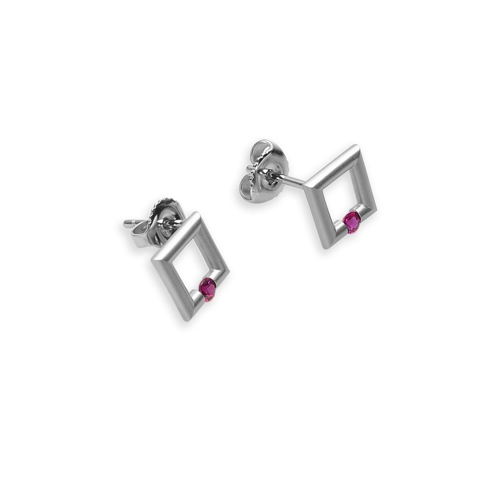 The Steven Kretchmer Micro-Square stud earrings are handcrafted in platinum with a matte finish. Each earring features a tension-set 2.5mm round ruby (0.14ctw.). The rubies are a vibrant red with the classic ruby pink undertone. Platinum friction