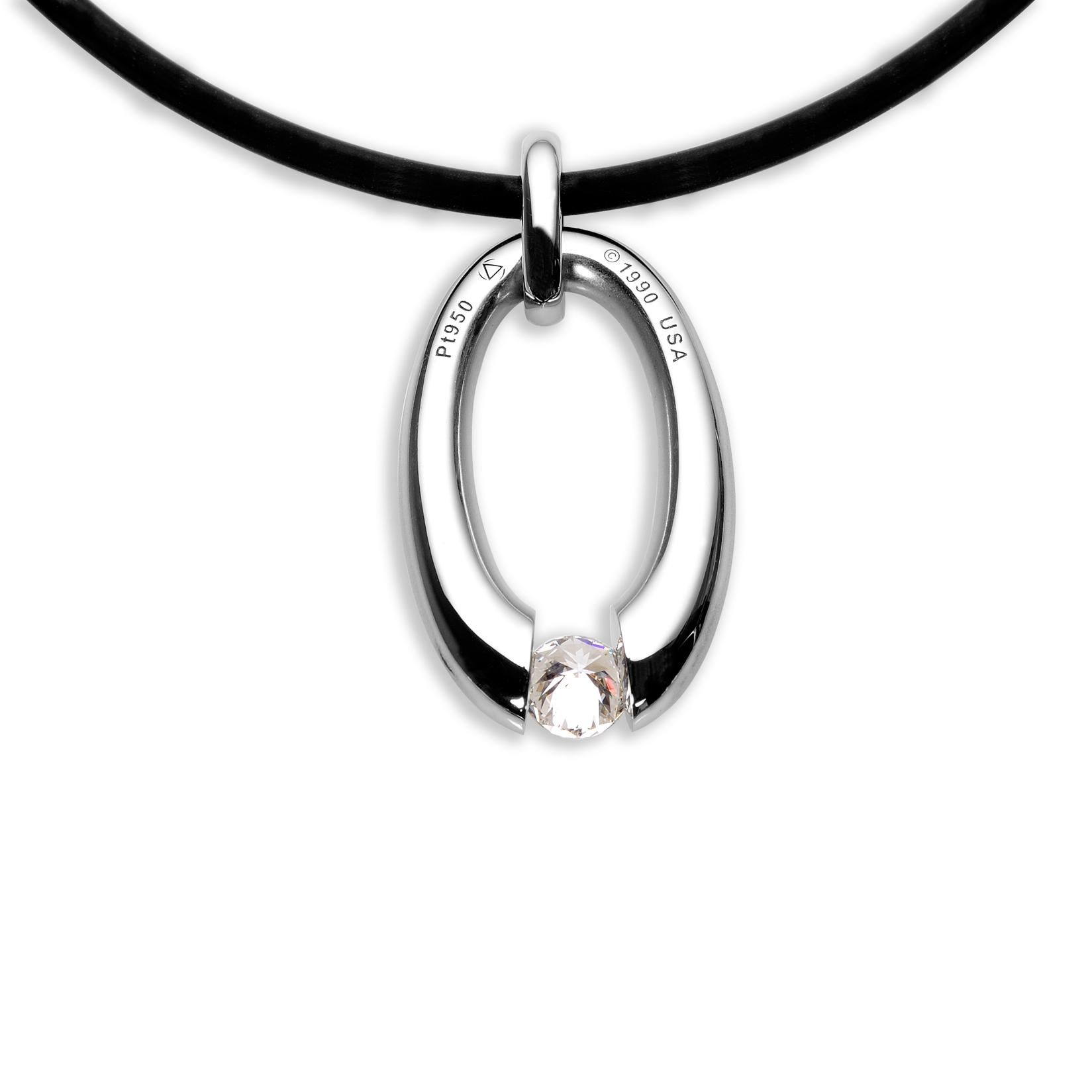 The Steven Kretchmer Small Oval Pendant with a tension-set diamond is handcrafted in a half-matte platinum with a shiny platinum bail. The 0.34 ct diamond is a brilliant round cut, F color, and has VS clarity. The pendant features a scattered melee