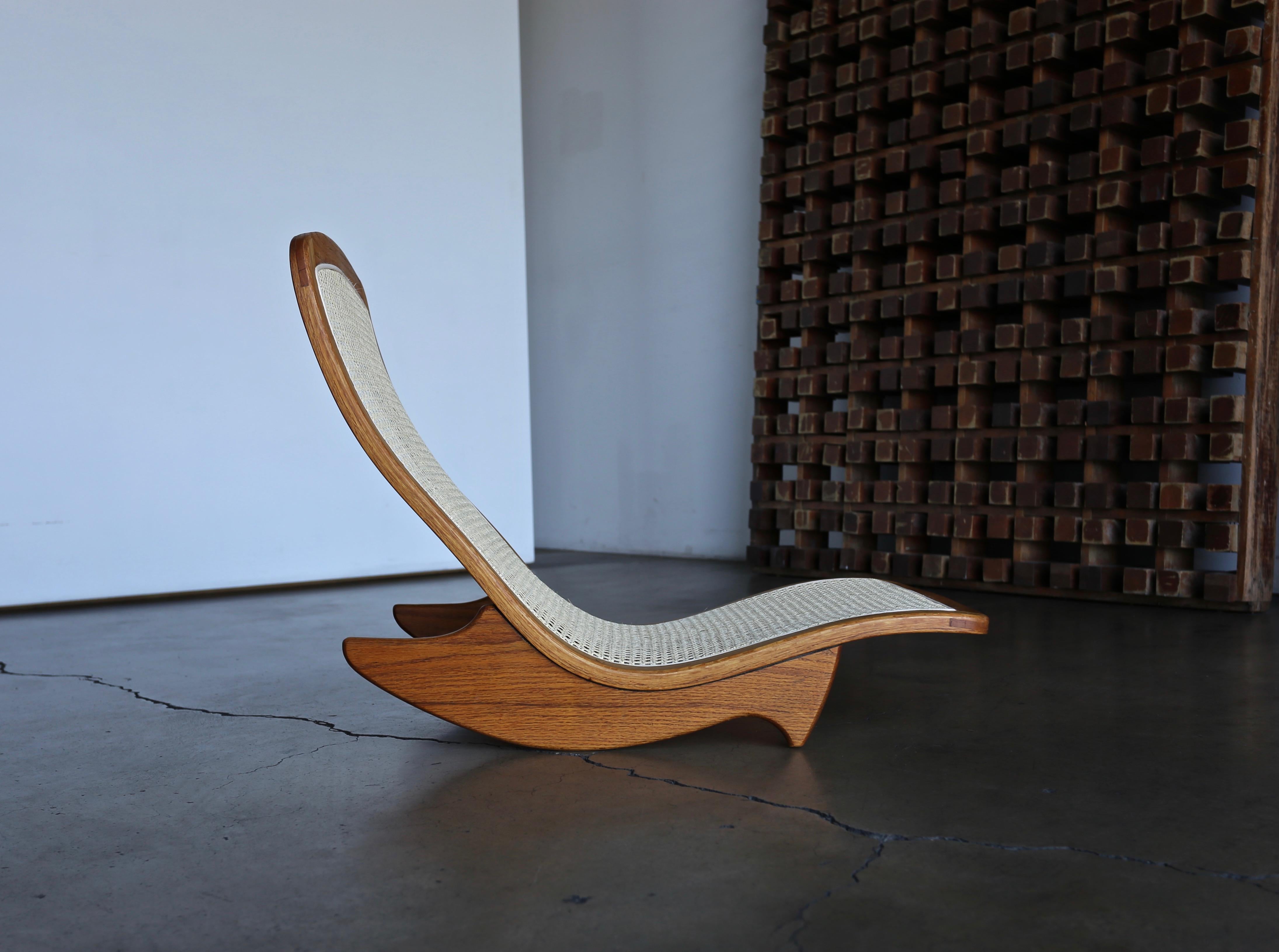 Handcrafted low rocker in oak and cane by California Artist, Steven Rieman. The design was exhibited at the Pasadena Museum of Art as part of the seminal California Design 76. Rieman was a graduate of the prestigious ArtCenter College and moved to a