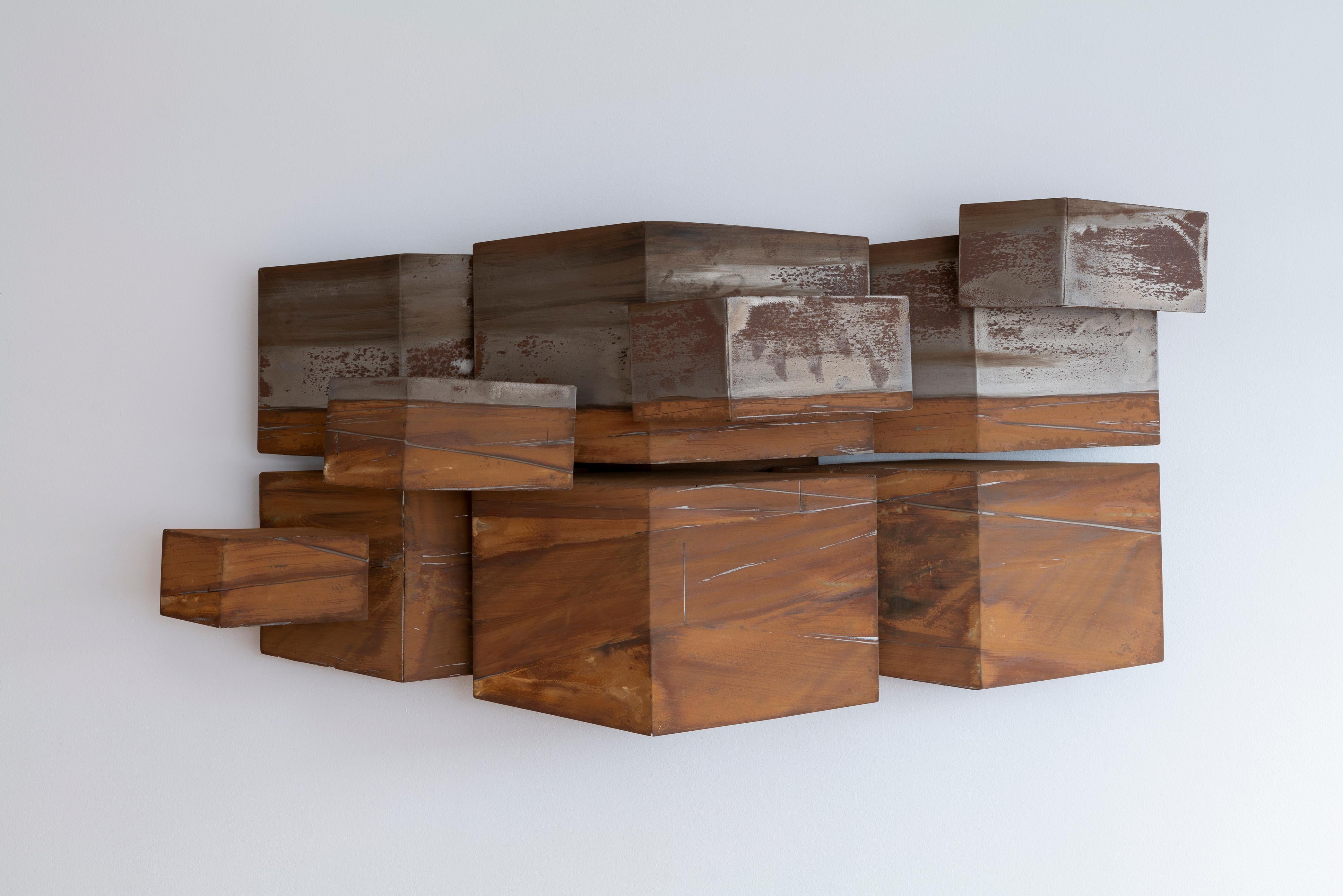 Une pièce d'art contemporain saisissante qui allie l'élégance industrielle à l'innovation artistique. Cette sculpture met en valeur la beauté audacieuse et texturée de l'acier brossé et oxydé, qui transforme sa surface en un étonnant jeu d'ombre et
