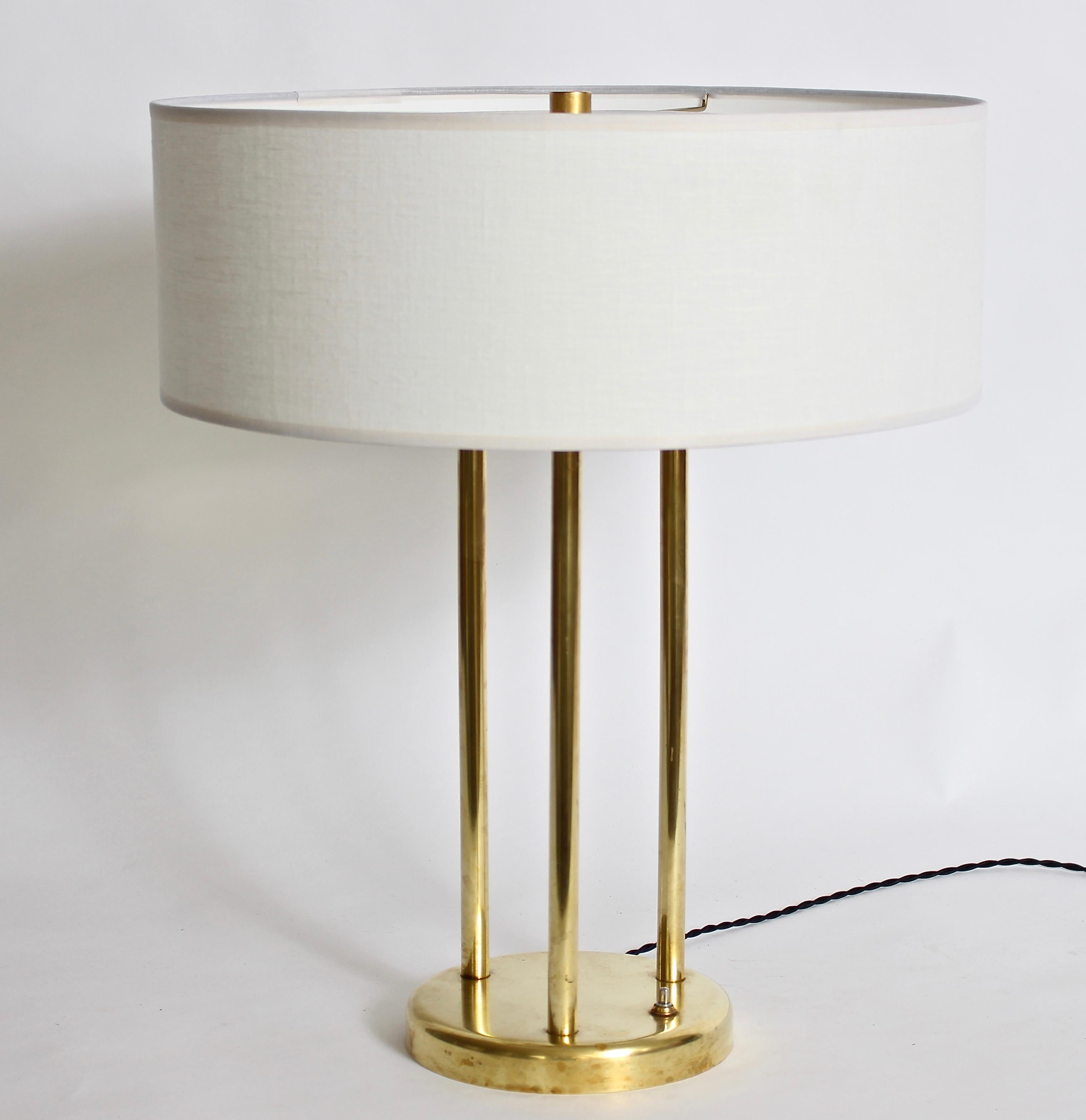 Stewart Ross James pour Hansen Lamp Company lampe de table réfléchissante en laiton. Le cadre à trois colonnes et la base circulaire sont en laiton.  Avec réflecteur à disque supérieur et épi de faîtage d'origine. Triple prise. L'abat-jour est