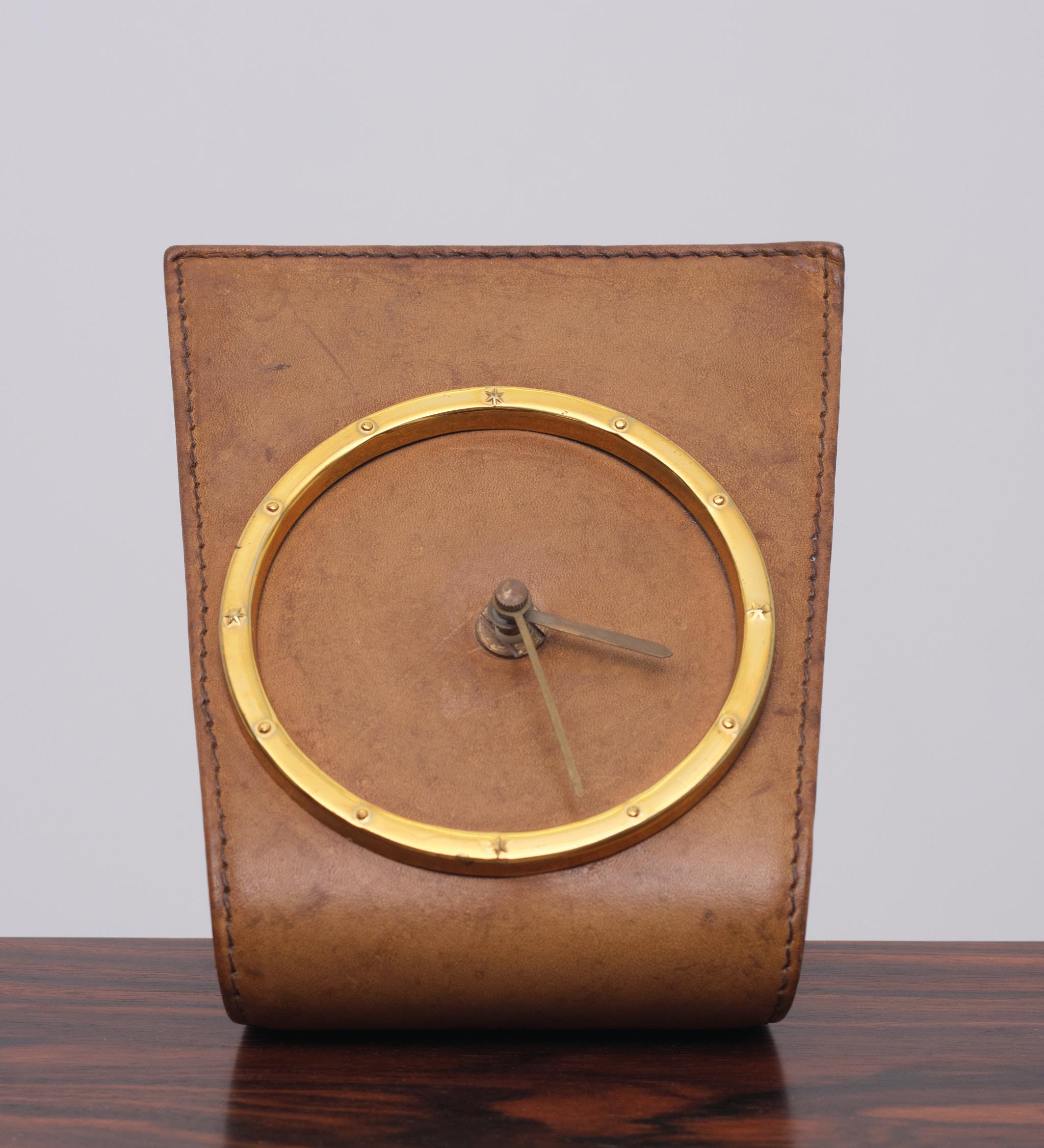 Very nice stich leather desk clock. Because its angle, Ideal to place 
on a Desk ore a low table. Comes with a quarts Junghans timepiece.
In a beautiful Cognac color.
   