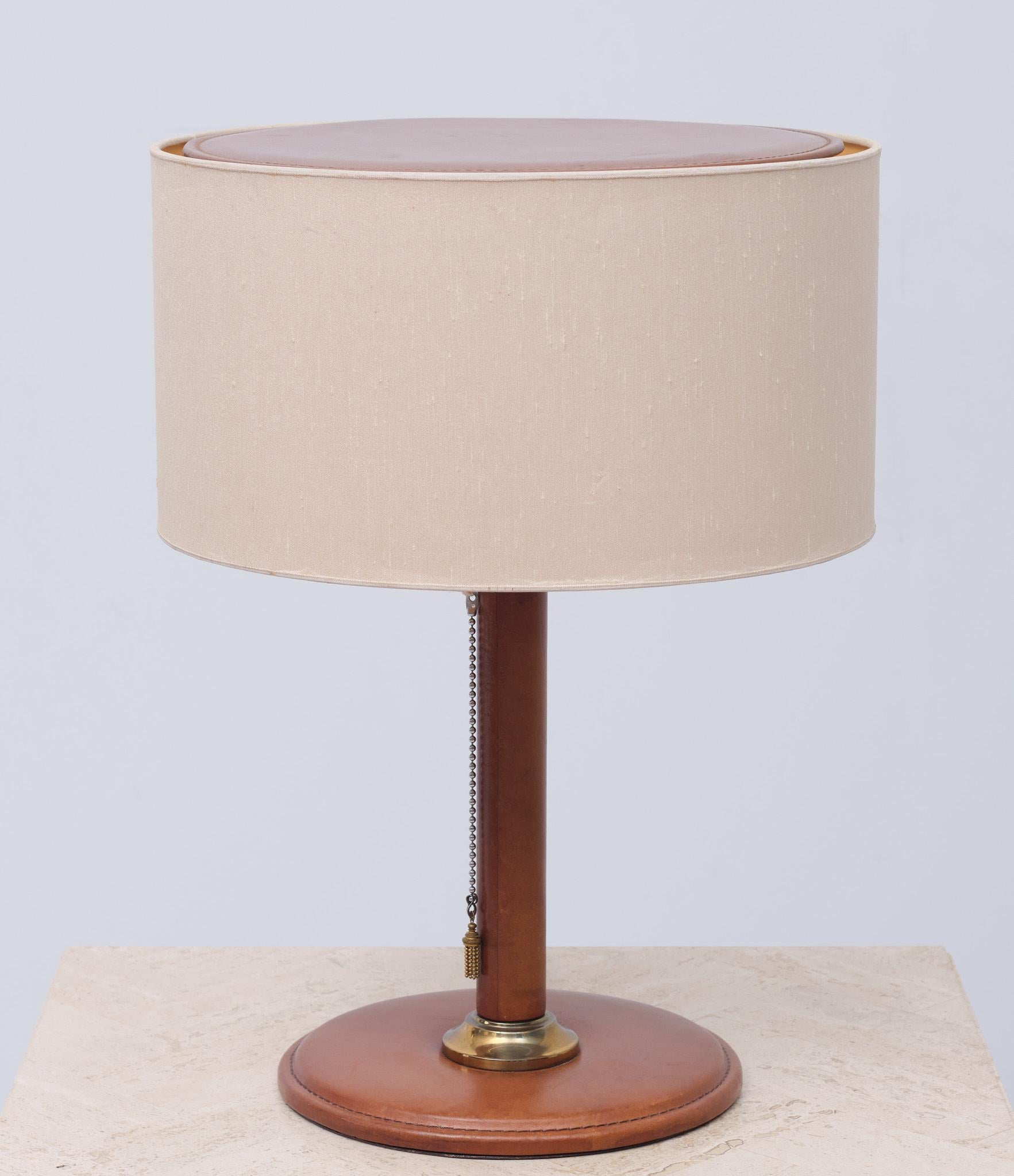 Very nice Stich Leather table lamp. Warm Cognac color, original Linen shade.
Creme color. 1 Large E27 bulb. Pull down switch. Like this model with the Leather lid on top of the shade. Good condition.
 