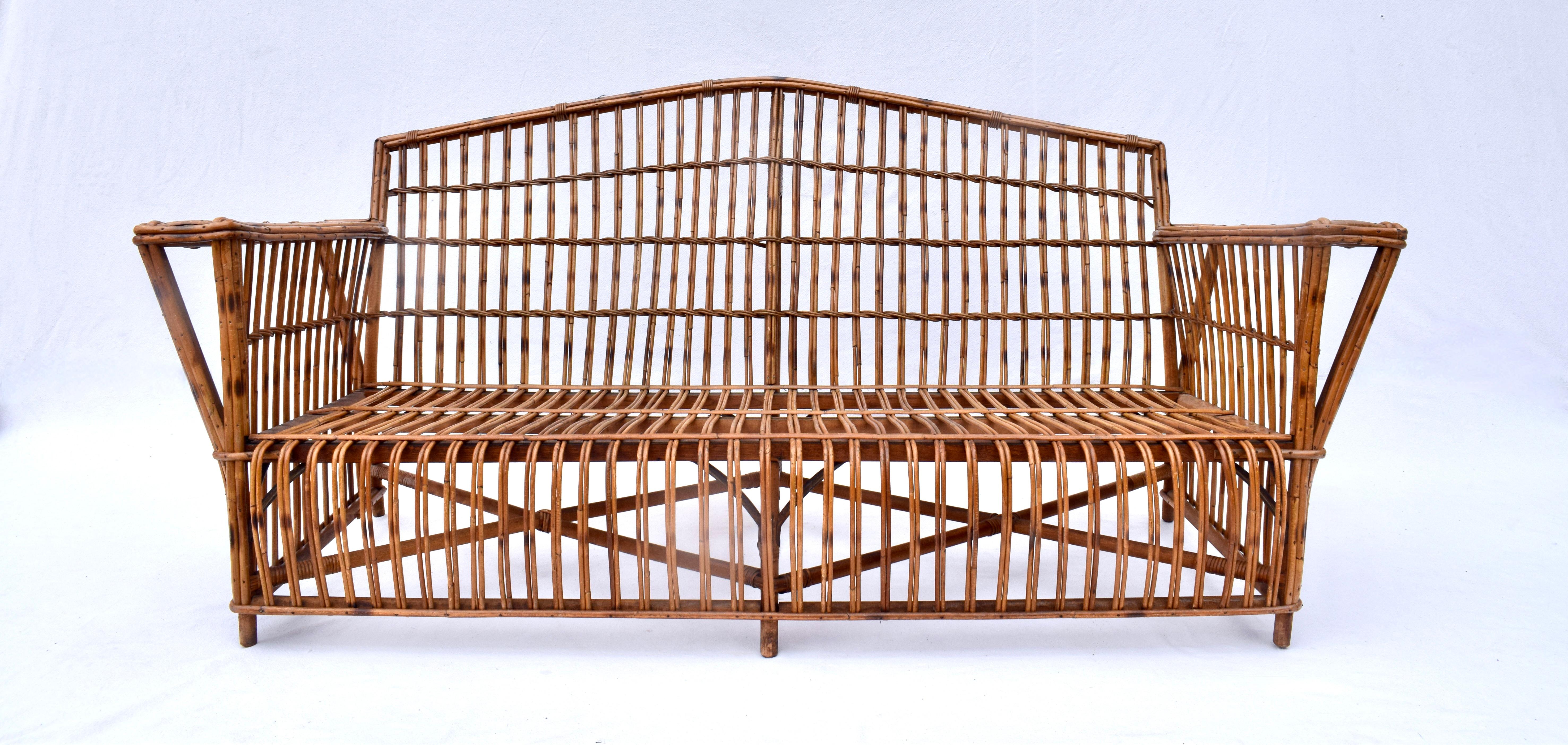 An early 20th c. stick wicker reed rattan sofa with original natural chestnut finish & new custom cushions. Nice mid size exquisitely maintained & fully hand detailed ready for use.  Seat/ Arm Dimensions: 18