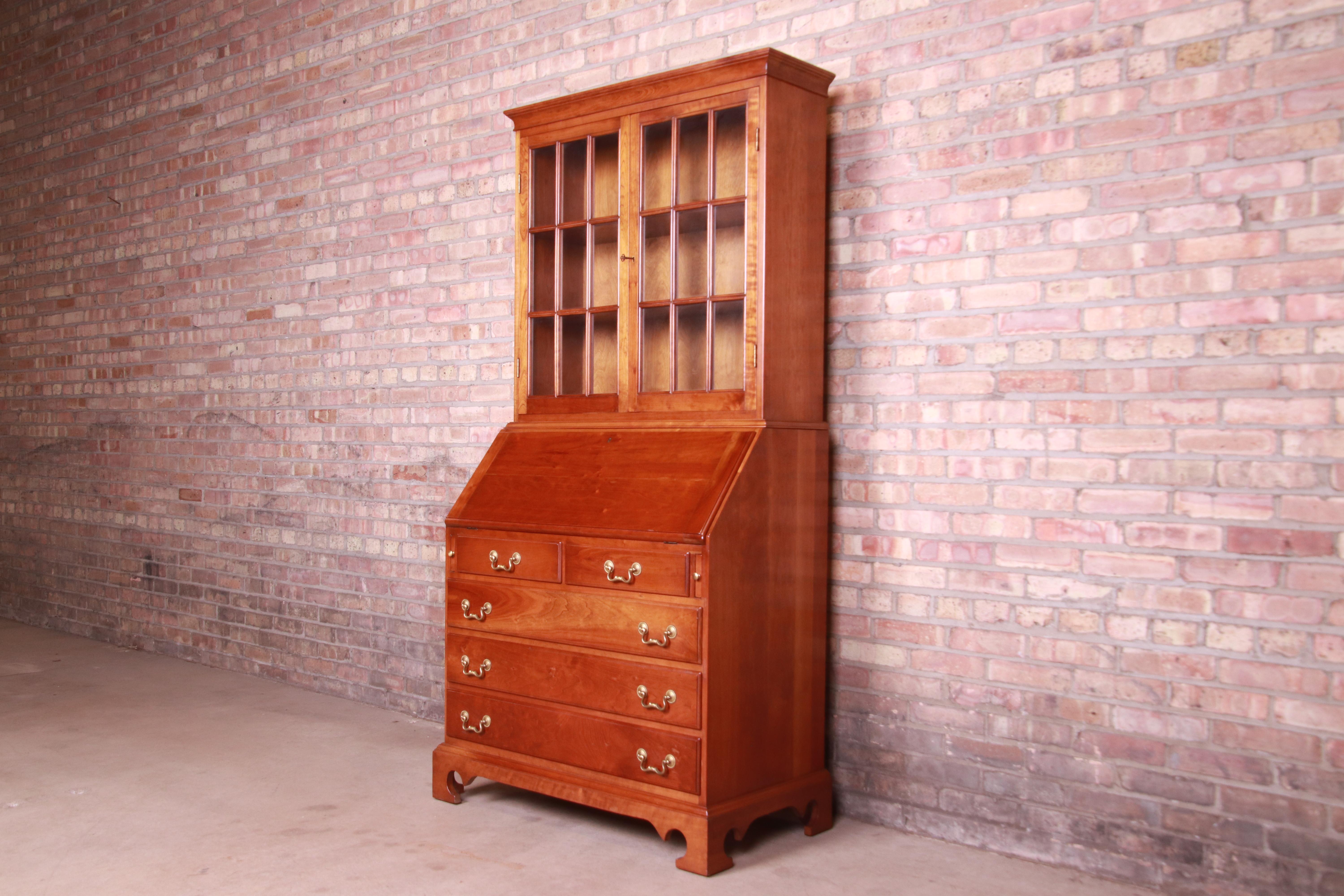 A gorgeous mid-century early American style bureau with drop front secretary desk and bookcase hutch top

By L. & J.G. Stickley

USA, 1961

Solid cherry wood, with mullioned glass front bookcase and original brass hardware.

Measures: