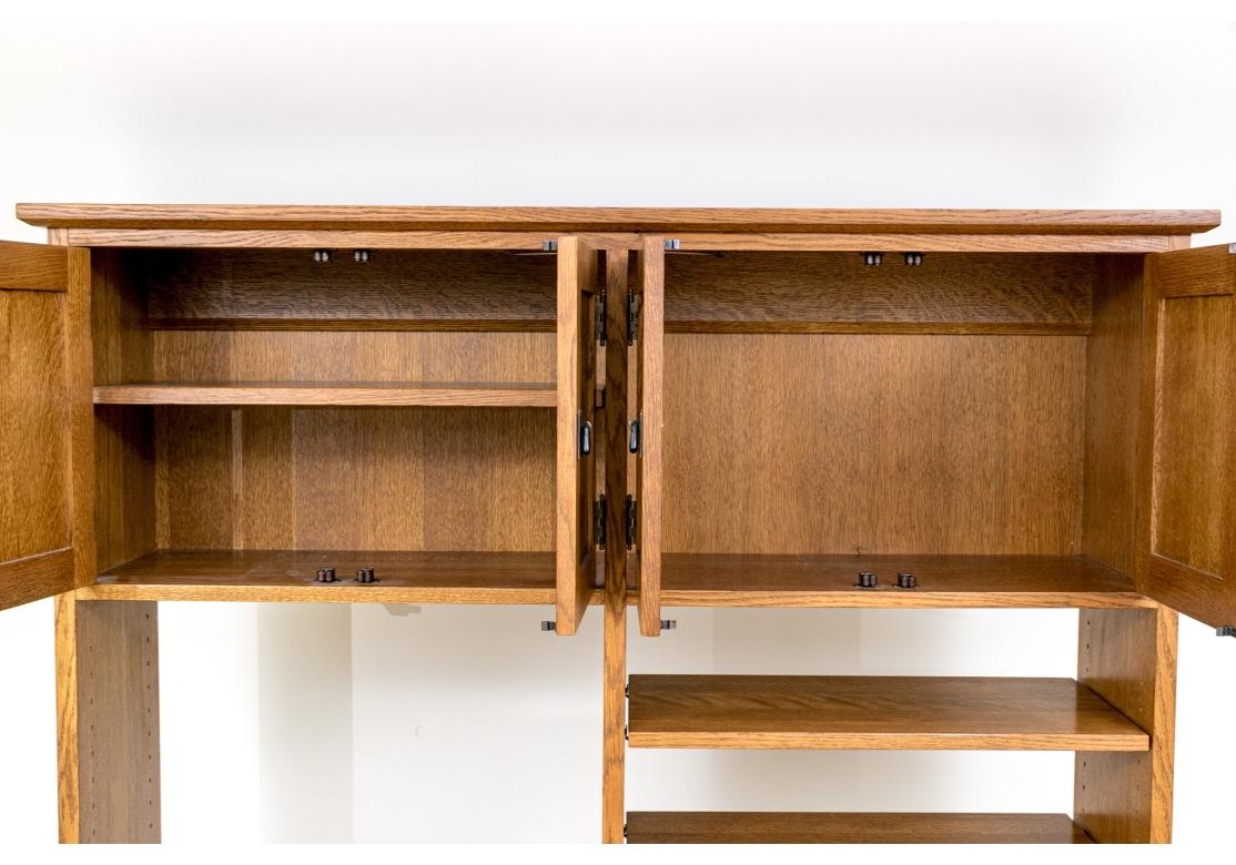 Stickley Arts & Crafts oak desk with three drawers having copper hammered hardware in a darkened patina. The desk with slatted side panels rests upon square legs. It is accompanied by a removable hutch top with paneled cabinet doors the conceal full