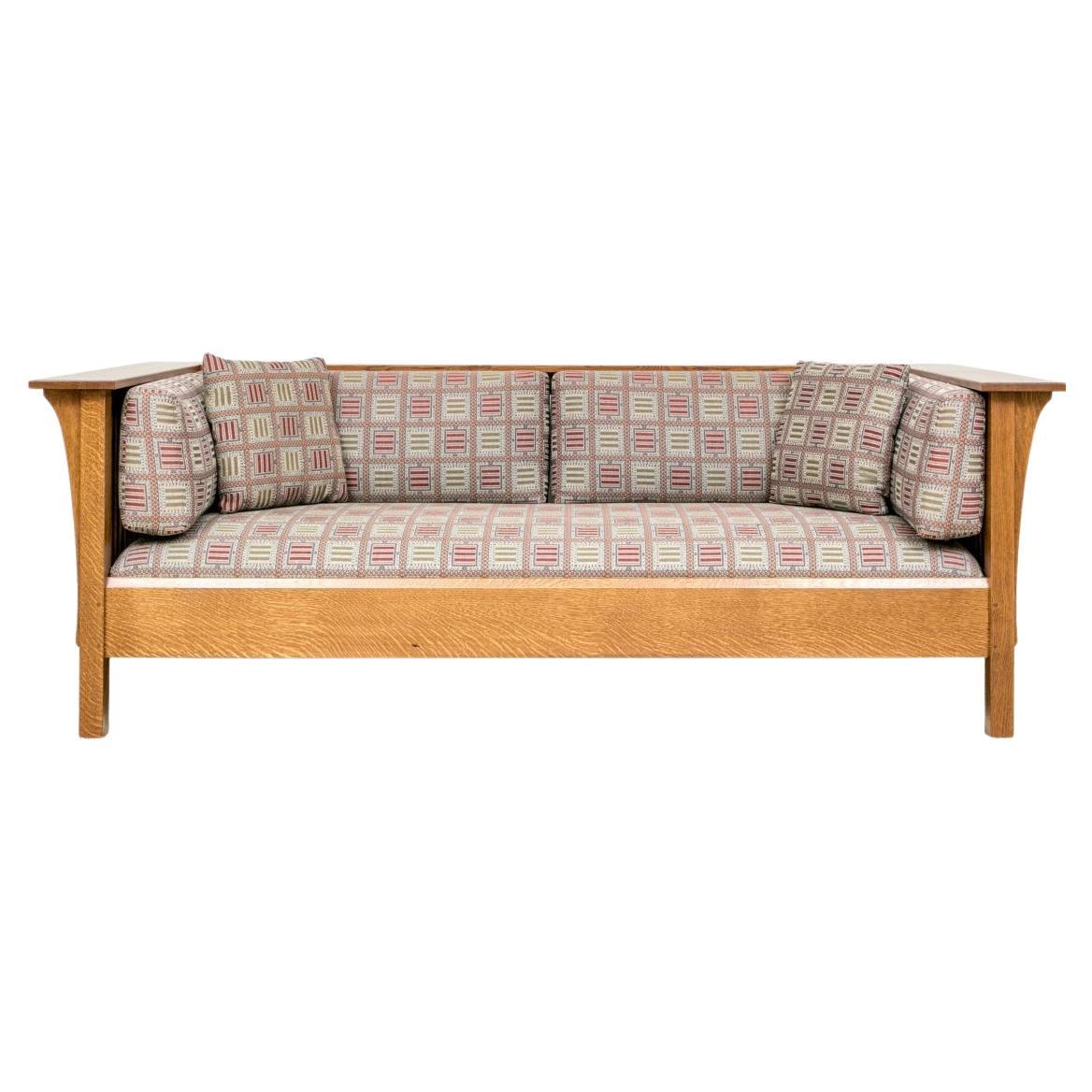 Sofá Stickley de roble con brazos iguales, tapizado en tela geométrica, con estructura de husillo, ménsulas bajo los brazos, medallón shopmark y logotipo Stickley grabado a fuego, y elevado sobre patas cuadradas.

Dimensiones: 84,5