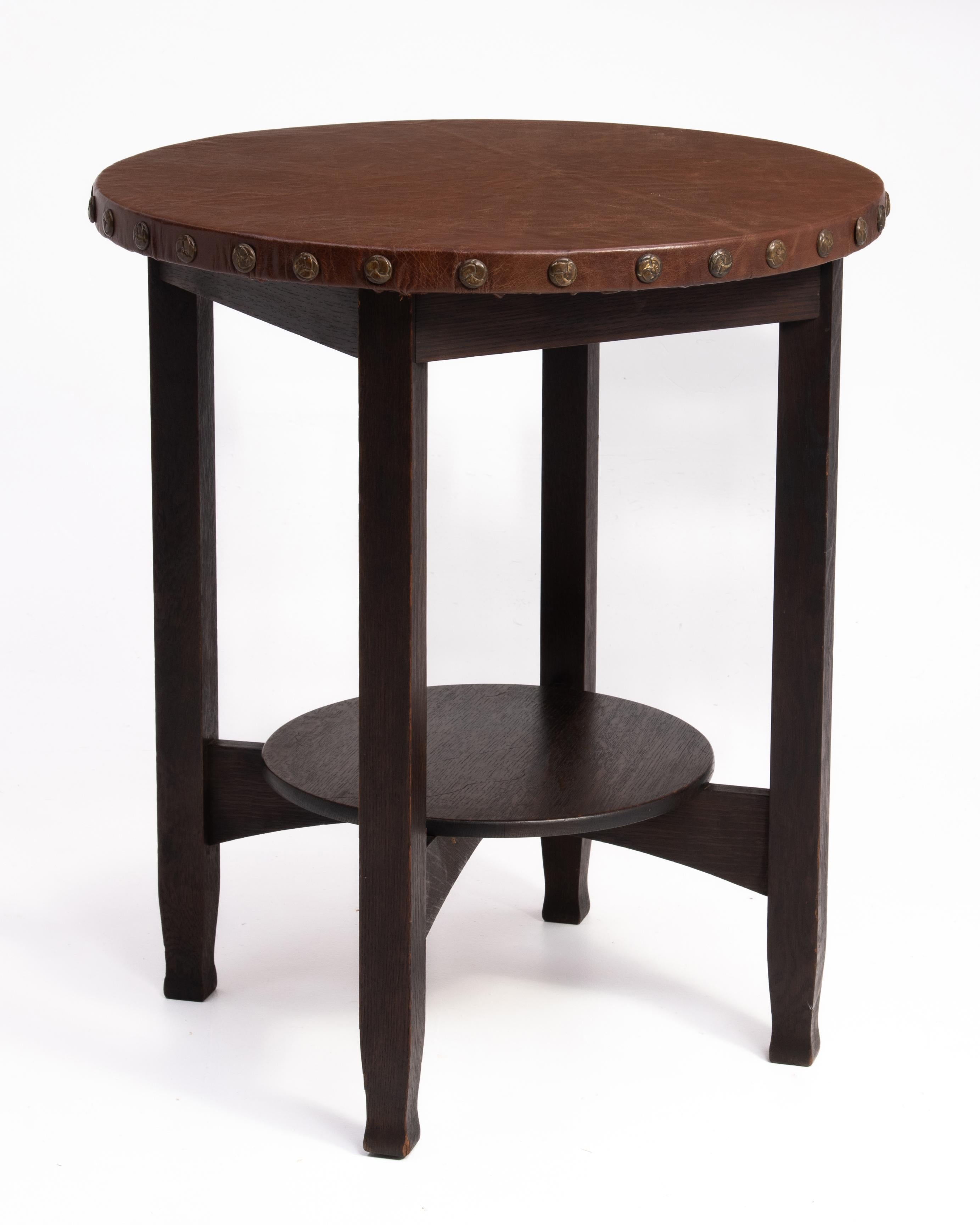 A Stickley Brothers Mission Oak or Arts and Crafts Leather top lamp table. The table is marked with the remant of the oval 