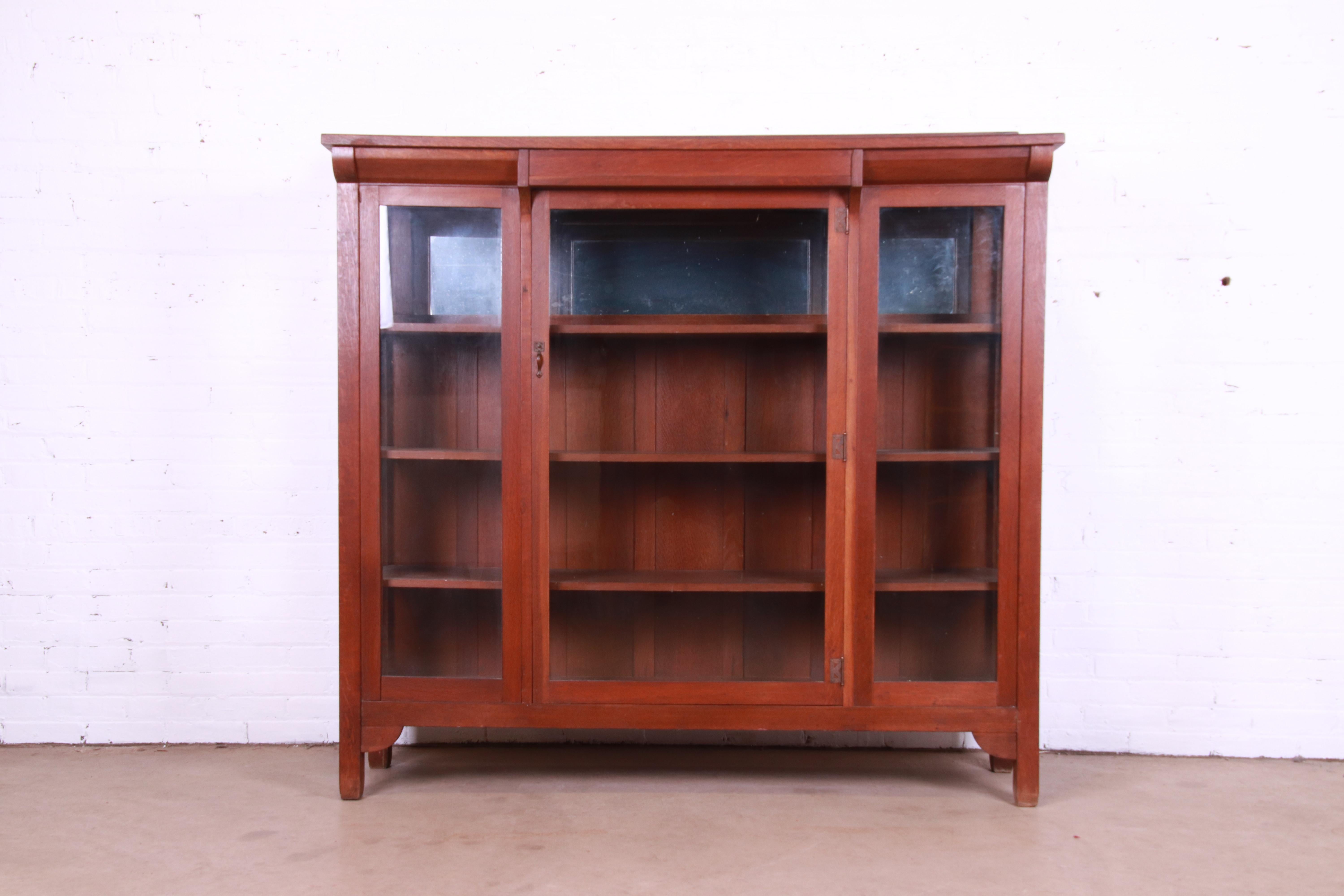 A gorgeous antique Arts & Crafts bookcase or display cabinet

By Stickley Brothers

USA, Circa 1900

Carved quarter sawn oak, with glass front doors and sides, mirrored back on top shelf, and copper hardware.

Measures: 65.5