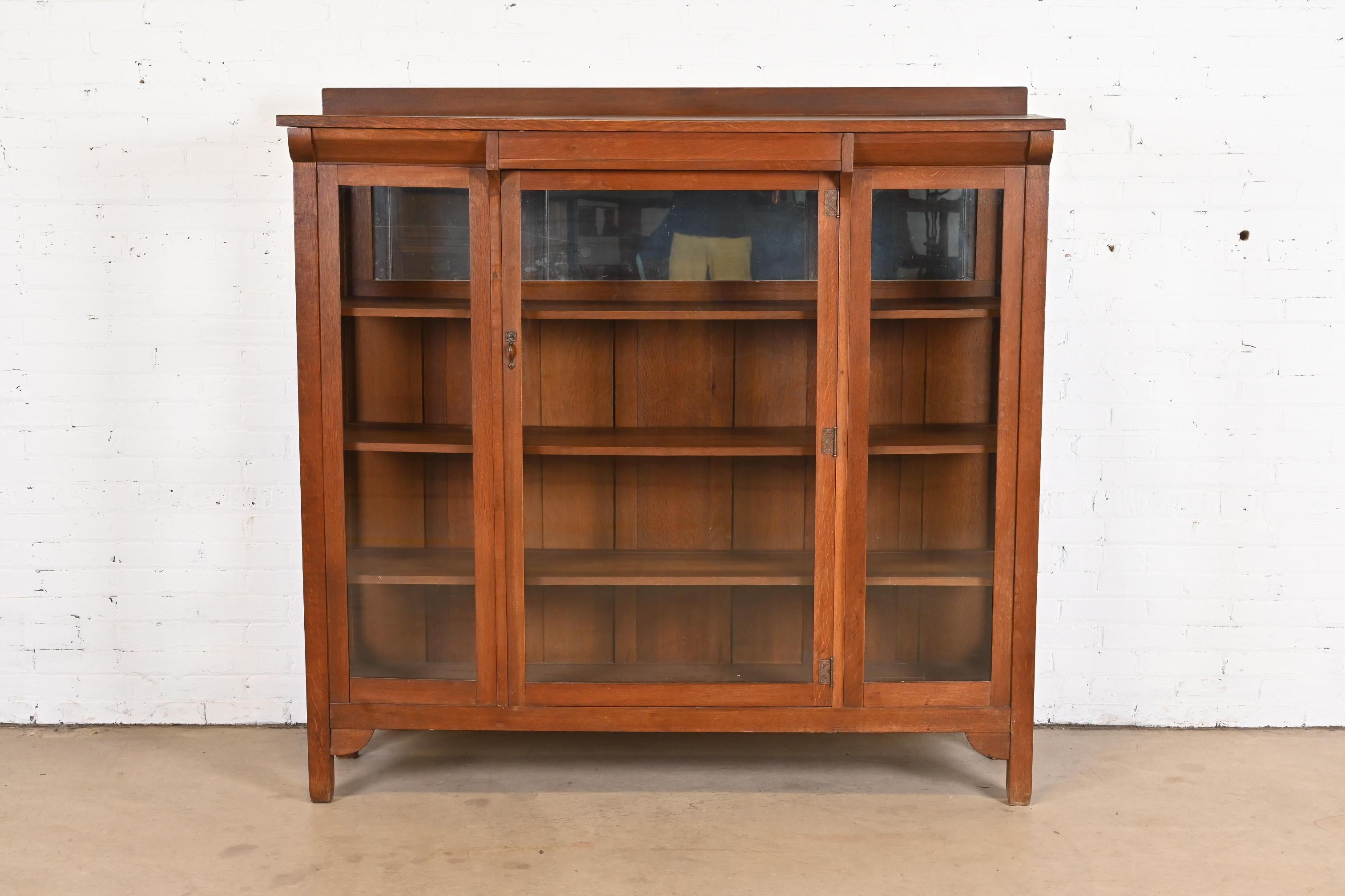 A gorgeous antique Mission or Arts & Crafts bookcase or display cabinet

By Stickley Brothers

USA, circa 1900

Carved quarter sawn oak, with glass front doors and sides, mirrored back on top shelf, and copper hardware.

Measures: 65.5