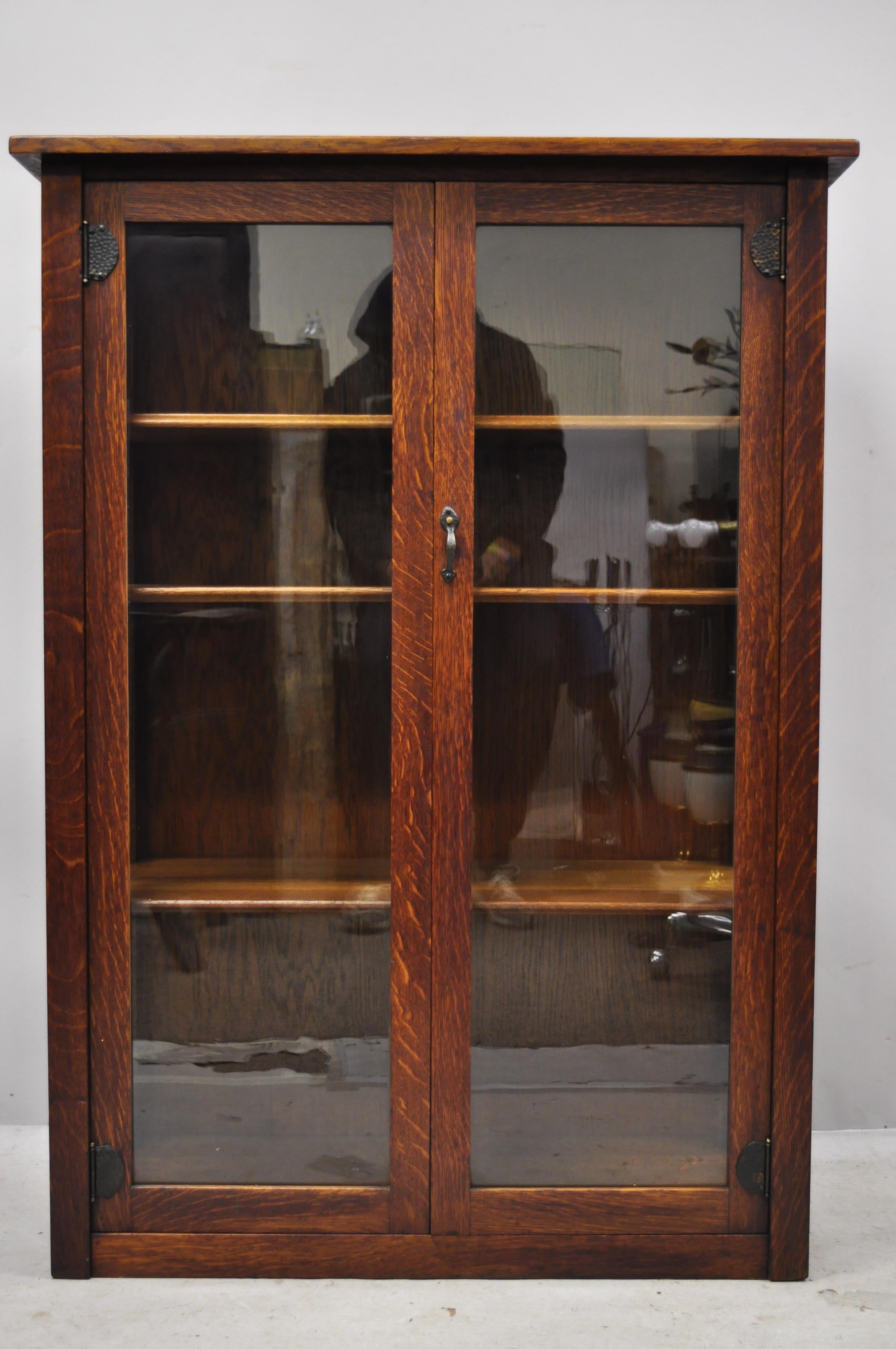 Stickley Brothers Quaint Furniture Mission oak two door bookcase china cabinet. Item features glass panel sides, 2 glass swing doors, hand hammered copper hinges, solid oak wood construction, 2 glass swing doors, original label, 3 adjustable