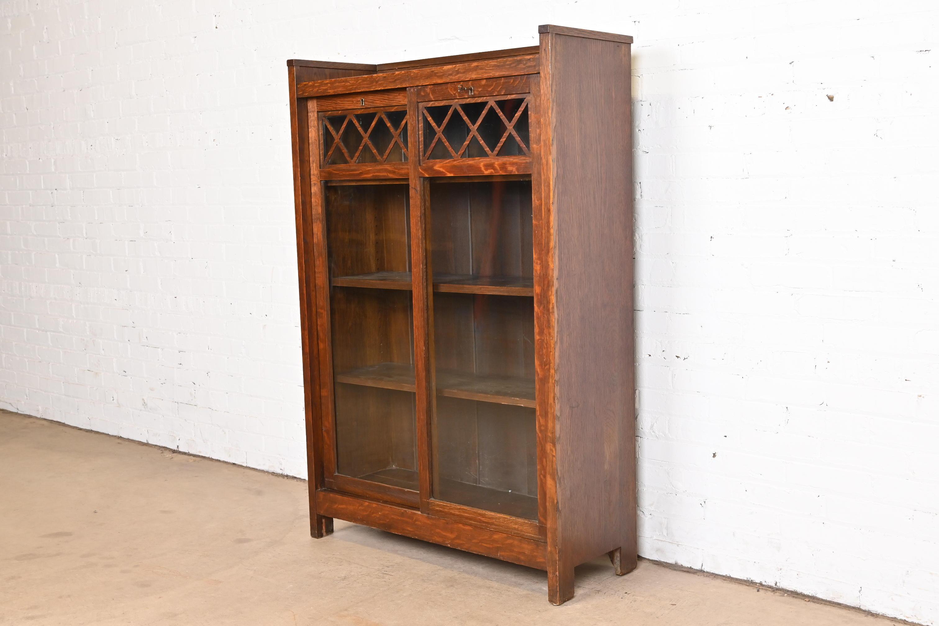 A gorgeous antique Mission or Arts & Crafts bookcase with sliding doors

In the manner of Stickley Brothers

USA, Circa 1900

Quarter sawn oak, with sliding glass front doors. Cabinet locks, and key is included.

Measures: 36